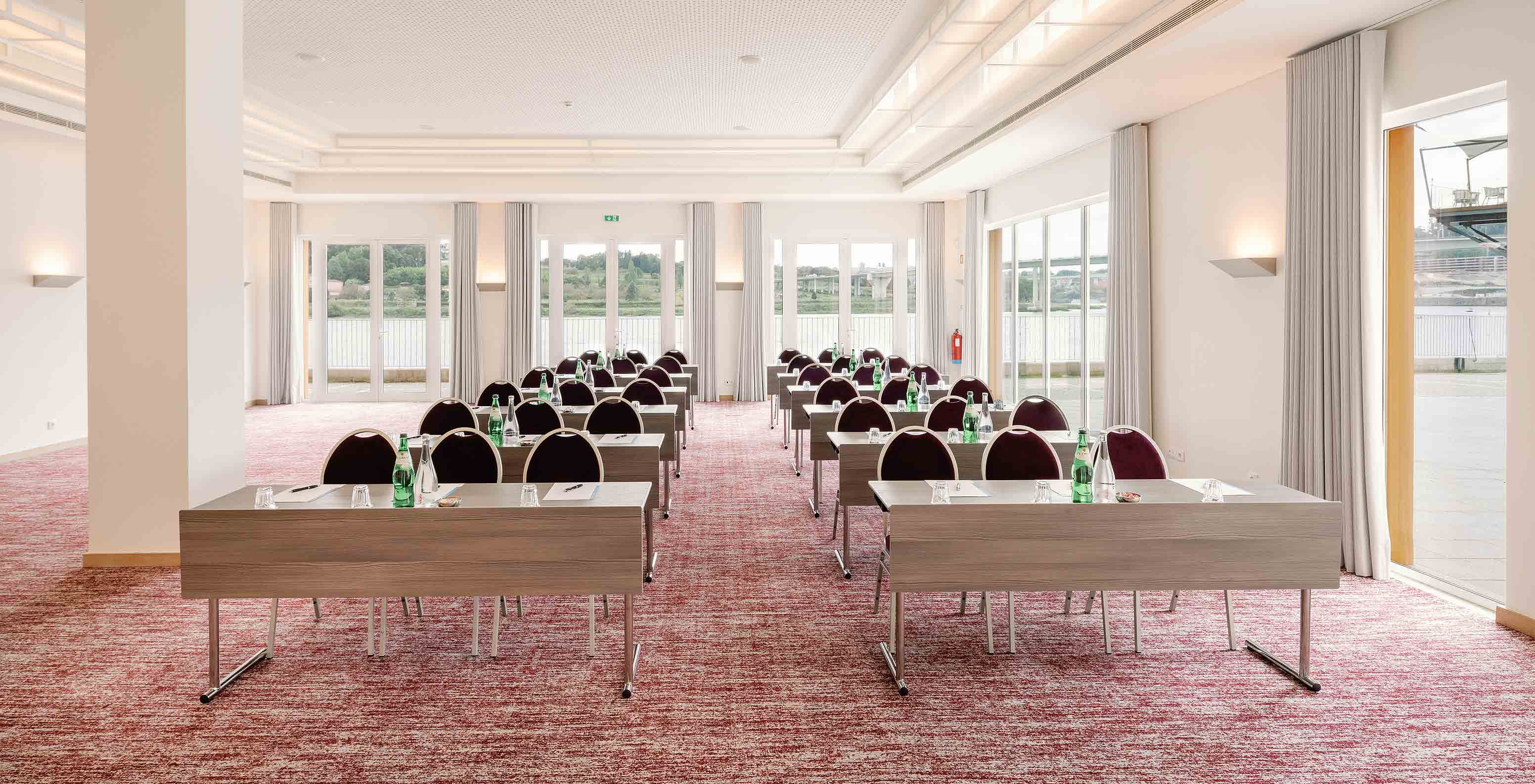 Douro V room with tables chairs and large windows at Pestana Douro Riverside Hotel with Pool by the Douro River