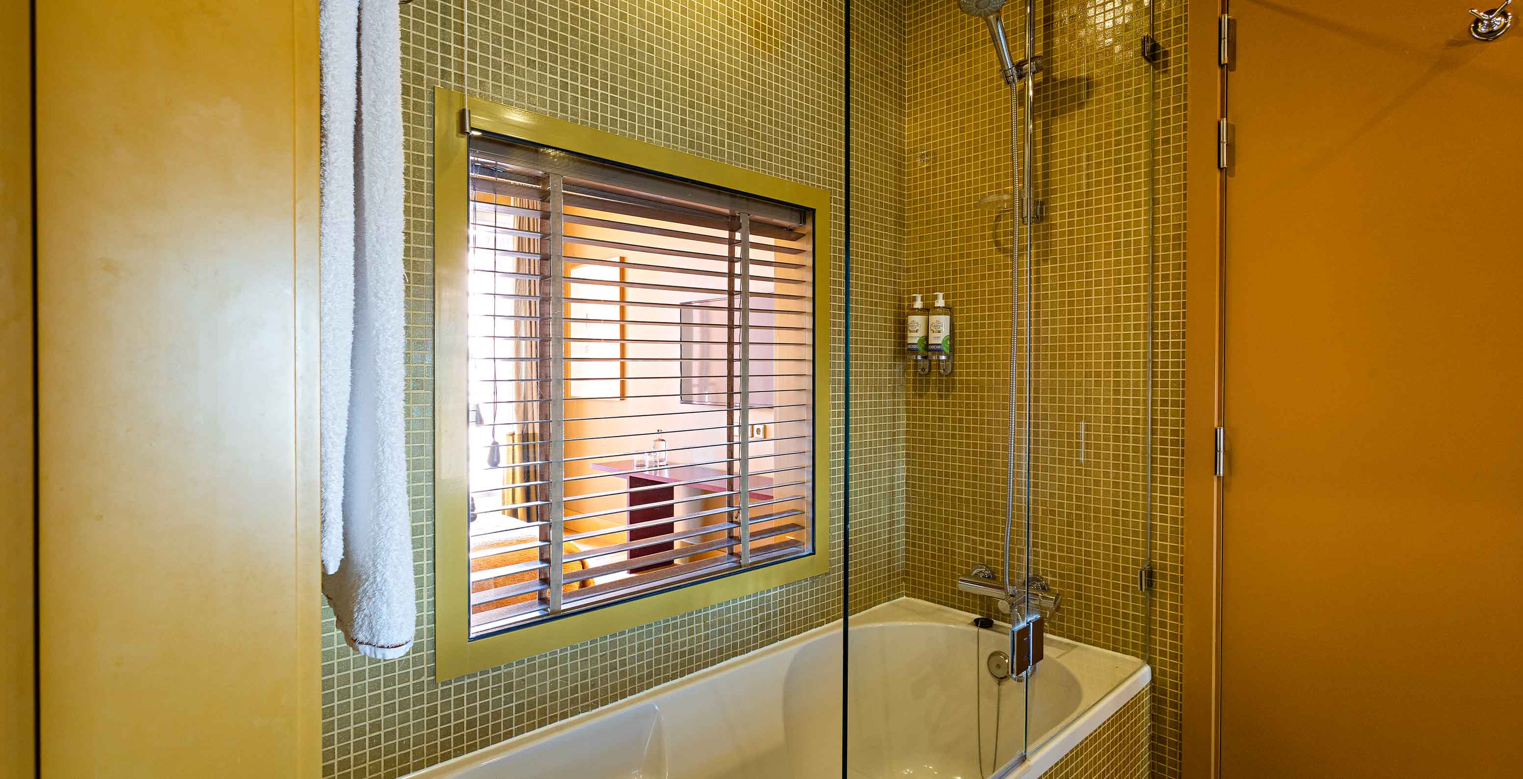 The Suite Balcony has a bathroom with a bathtub and a window to the bedroom