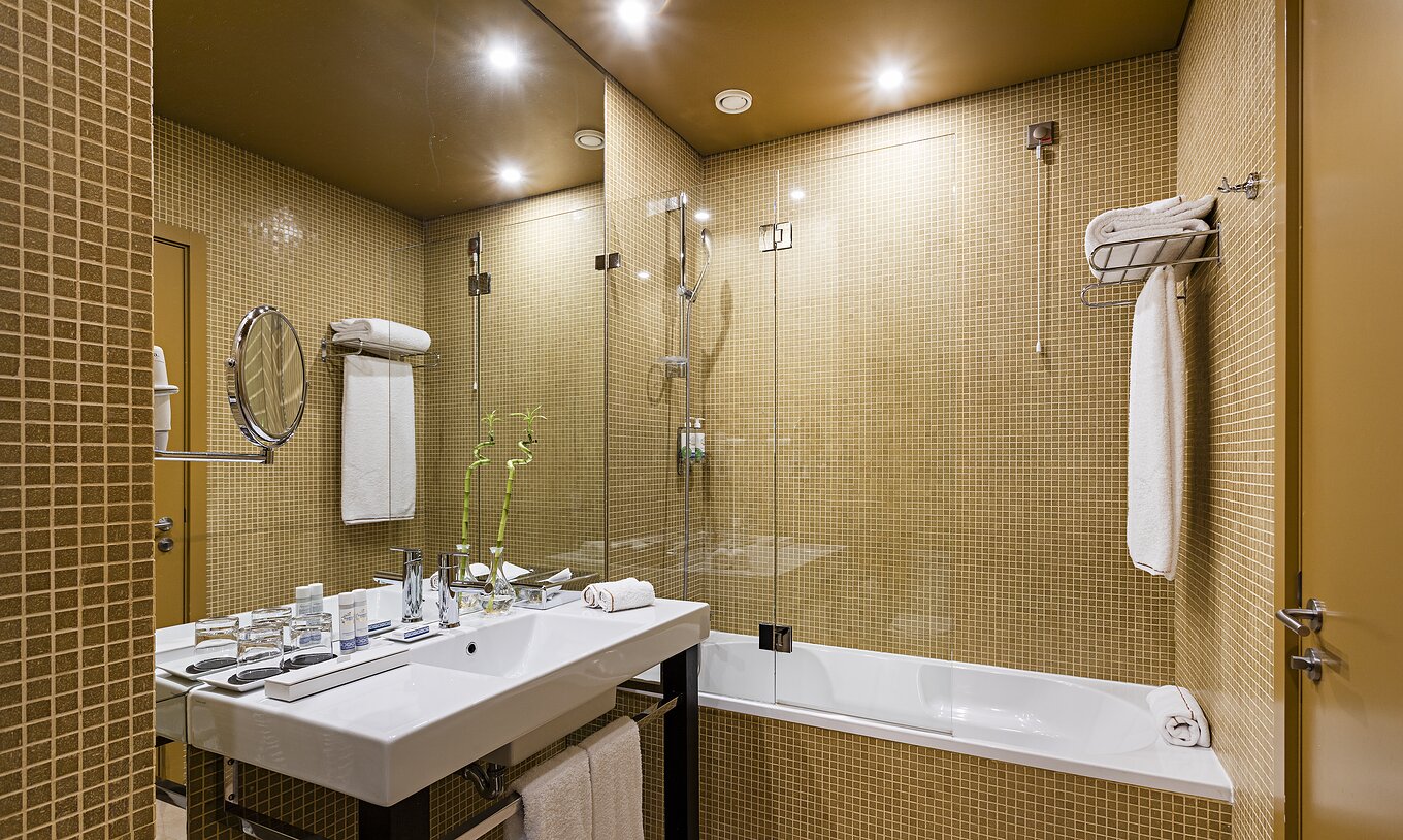 Pestana Palácio do Freixo’s Classic room has a bathroom with yellow tiles, toilet and bathtub