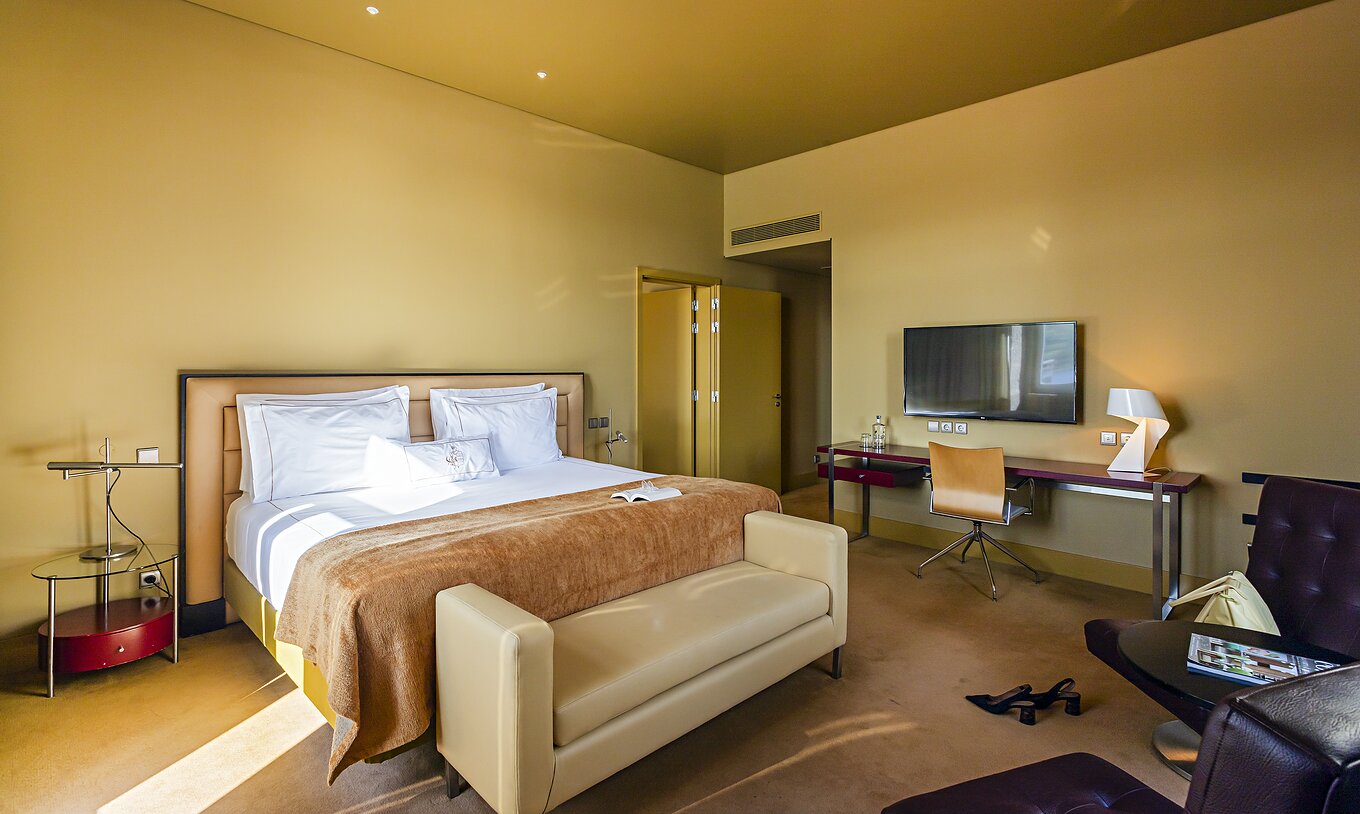 The Suite Nasoni has a bedroom with a double bed, two armchairs, and a desk