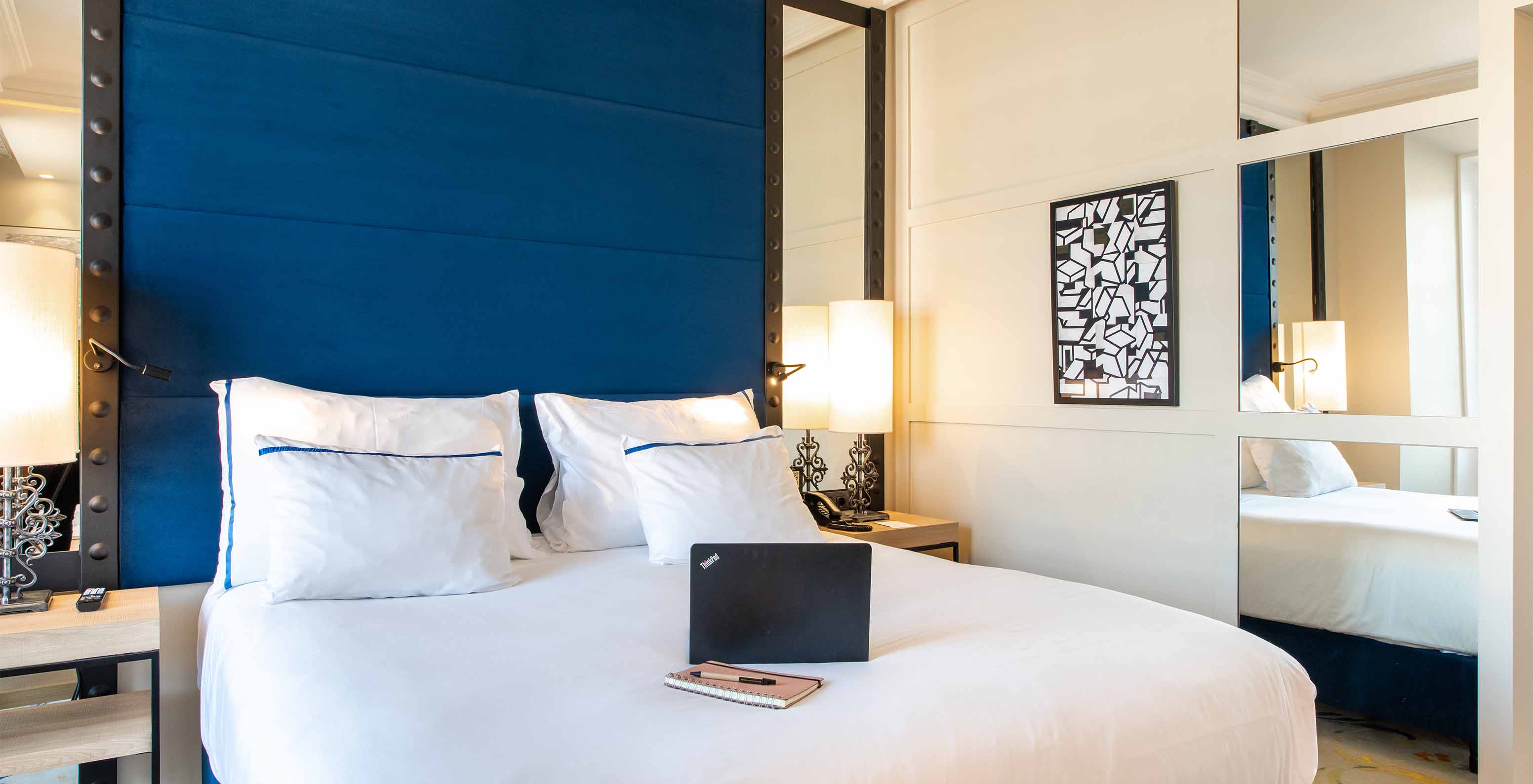 The Deluxe Plaza Mayor at Pestana Collection Plaza Mayor has a double bed, two bedside tables and a mirror on the wall
