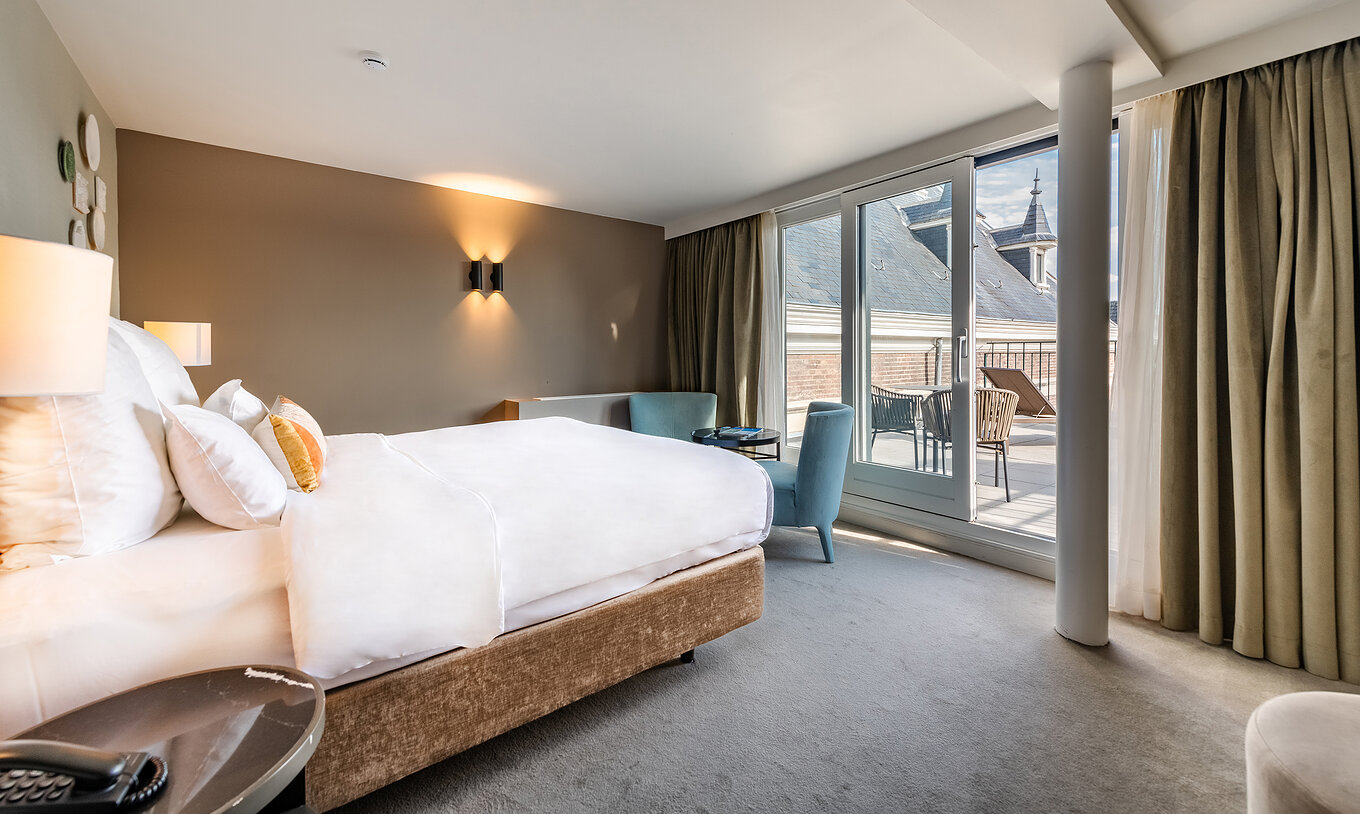 Executive Terrace room at Pestana Amsterdam Riverside has a double bed facing the balcony and two armchairs