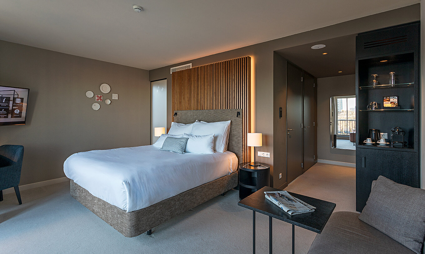 Premium - River View room at Pestana Amsterdam Riverside has a double bed, with bedside table and lamp