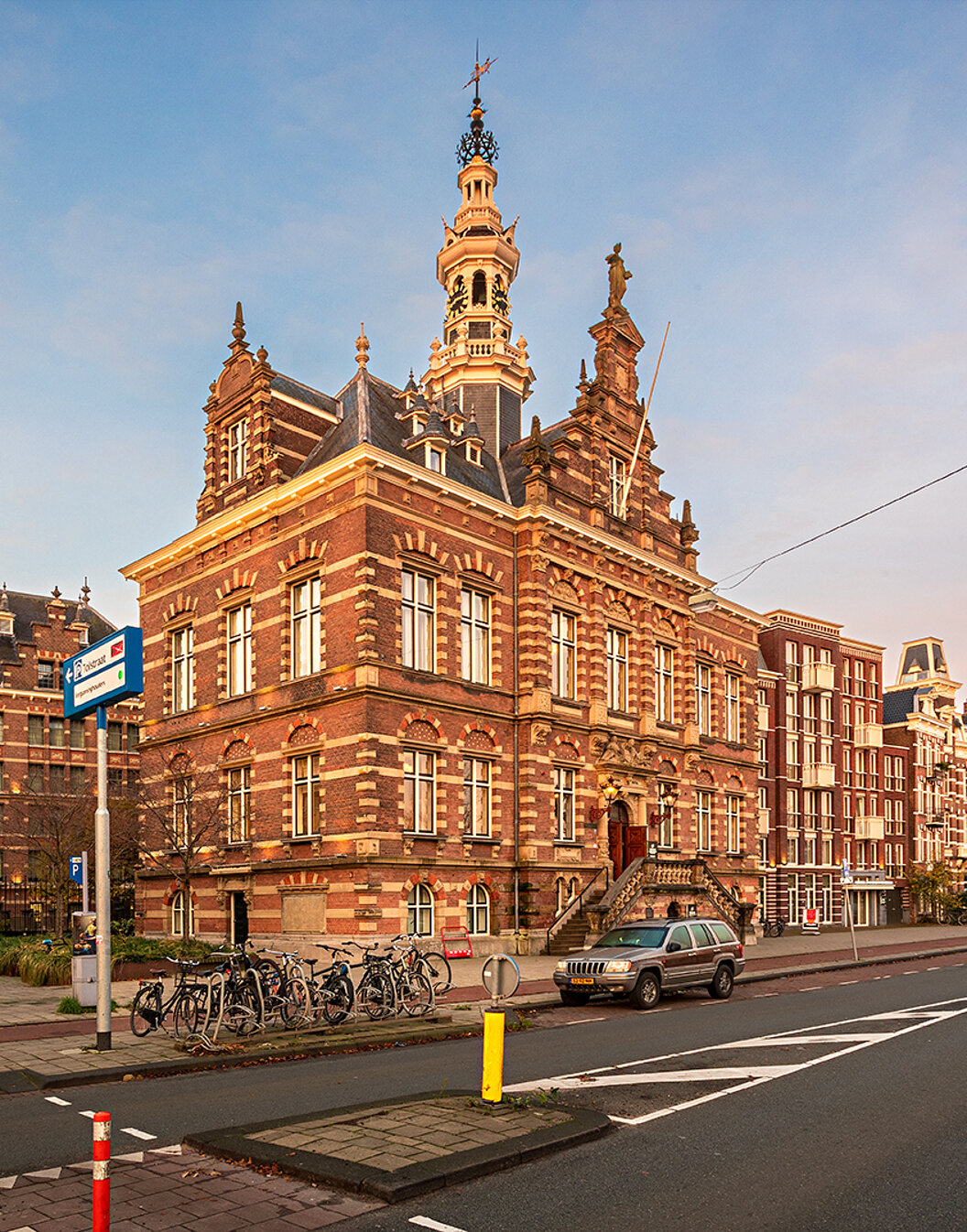 Exterior view of Pestana Amsterdam Riverside, with red bricks, parked bicycles, and a clear sky