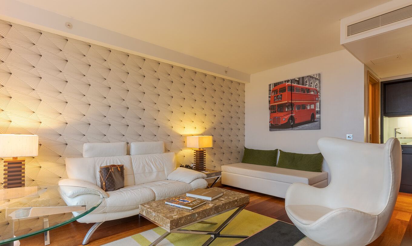The Executive One Bedroom Suite at Pestana Chelsea Bridge has sofa, ottoman, coffee table, glass table and armchair