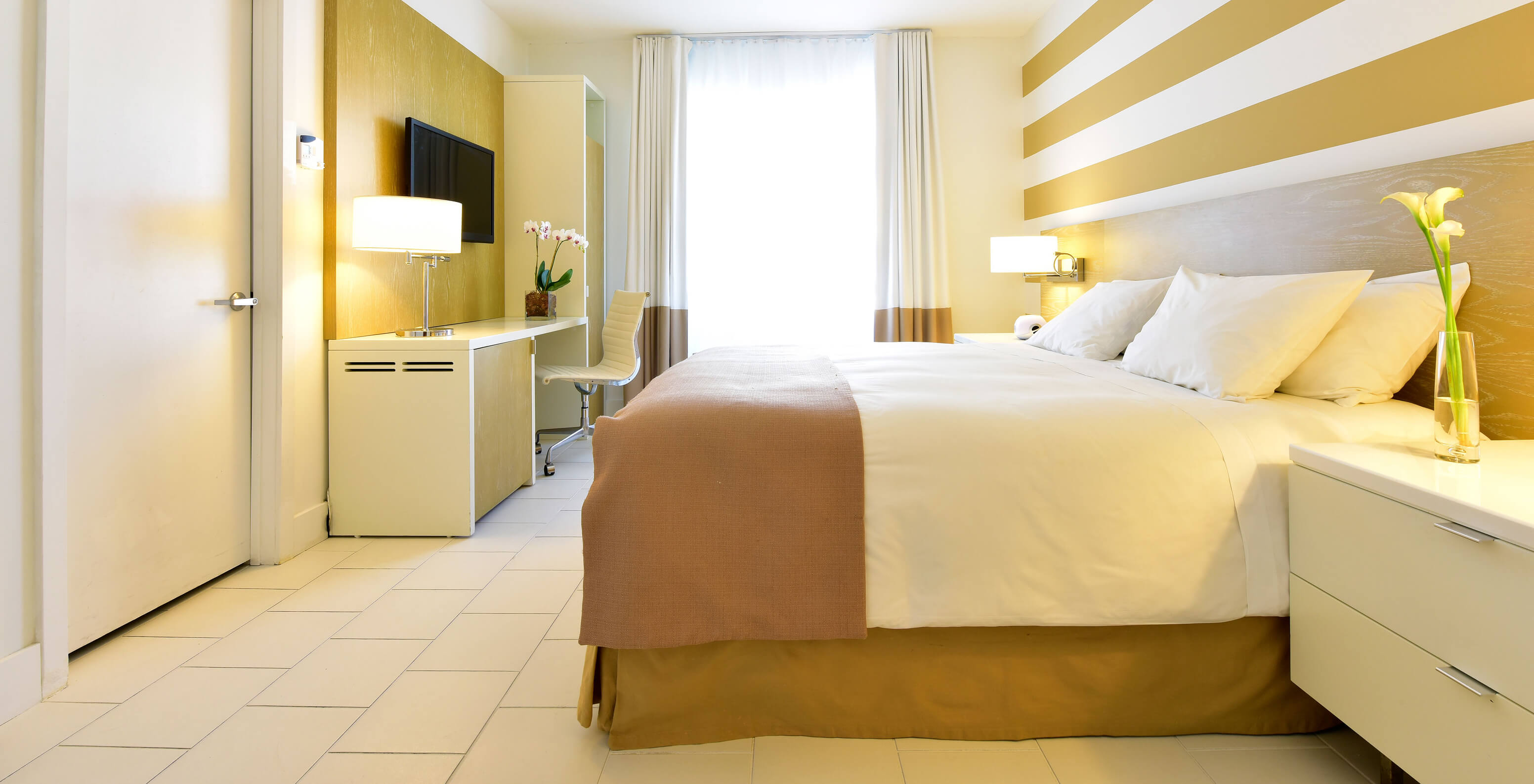 The Classic King - ADA at Pestana Miami South Beach has a double bed, bedside table, table and TV