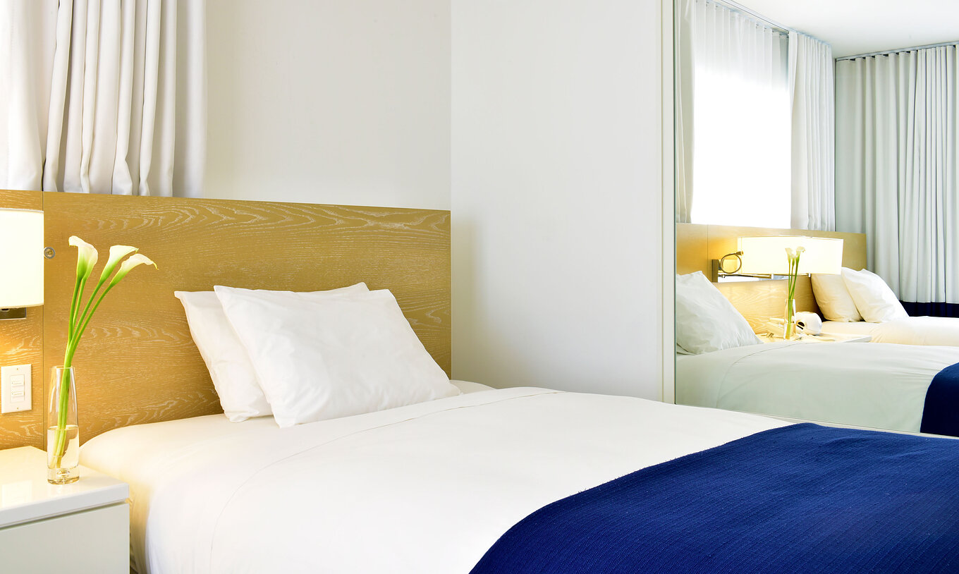 The Superior Double Queen Beds at Pestana Miami is a modern room with white bed and minimalist decor