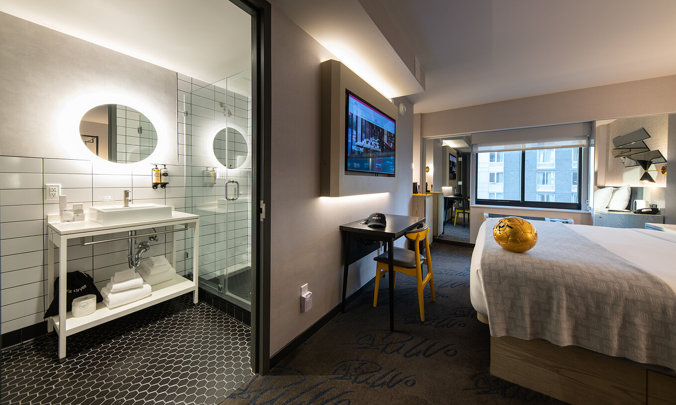 The Deluxe King Room at Pestana CR7 Times Square has a bathroom next to the room with a sink