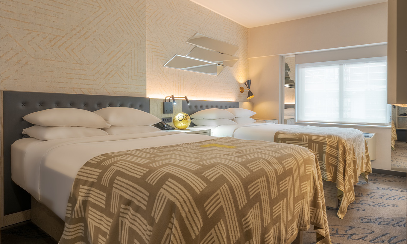 The Superior Double at Pestana CR7 Times Square has two beds with a bedspread with the number seven and a window