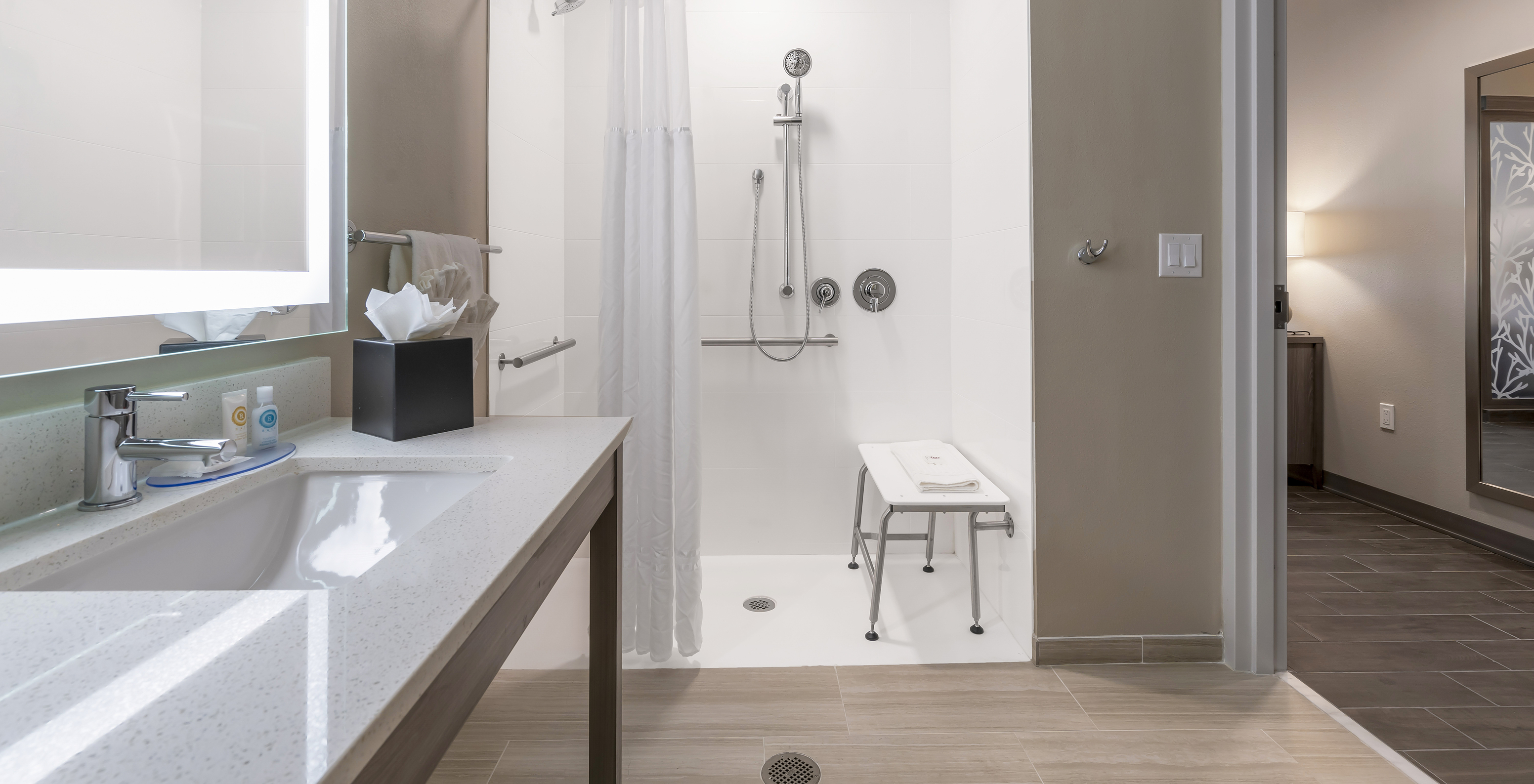 The ADA Double Queen Suite at Pestana Orlando Suites Lake Buena Vista features a bathroom with an adapted shower and sink