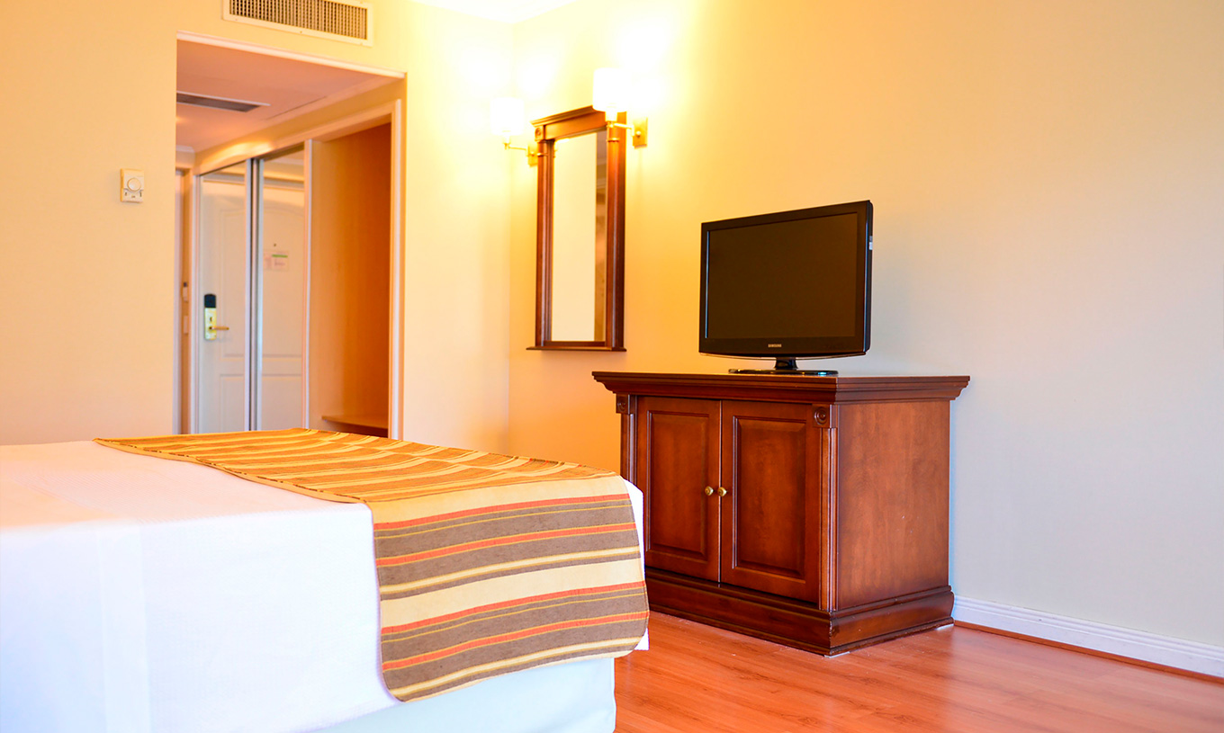 La habitación Twin Deluxe del Pestana Buenos Aires cuenta con televisión, armario y espejo