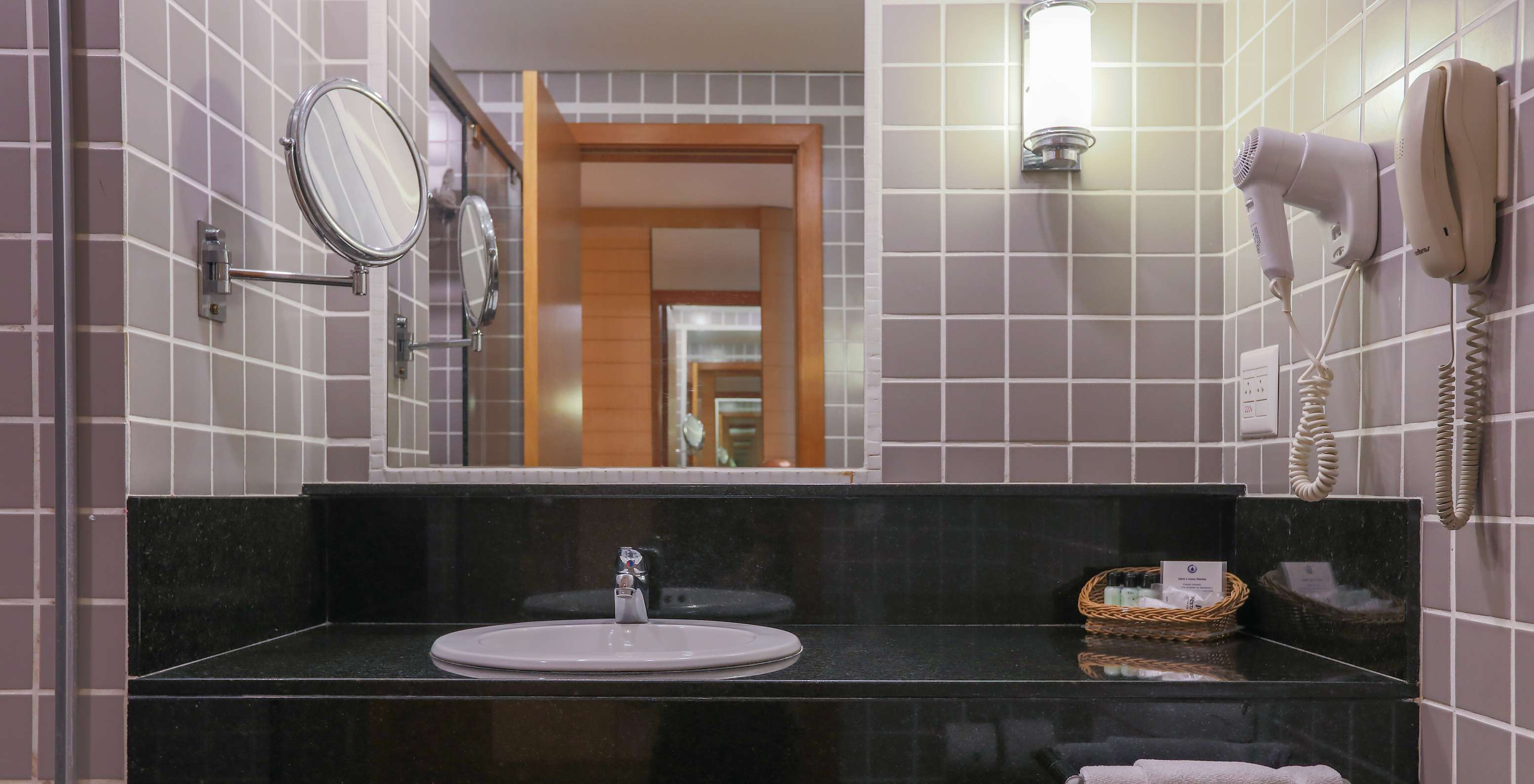 El Queen Estándar del Pestana Curitiba tiene un baño con azulejos grises y un lavabo negro