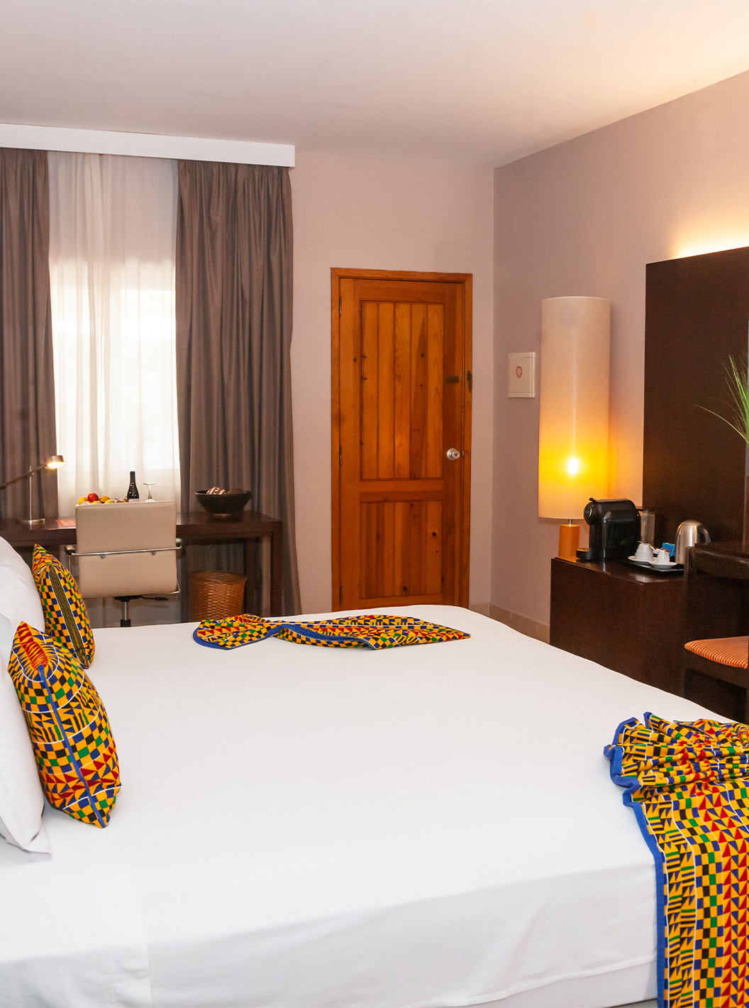 La Junior Suite del Pestana Tropico cuenta con cama de casal, televisión, espejo y escritorio con silla y cesto de fruta