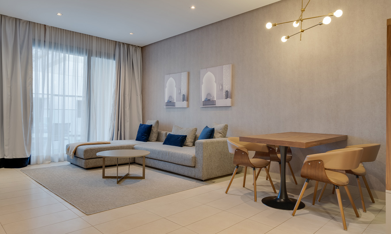 La Suite Familiar del Pestana Casablanca tiene un sofá gris grande con chaise longue al lado de la ventana