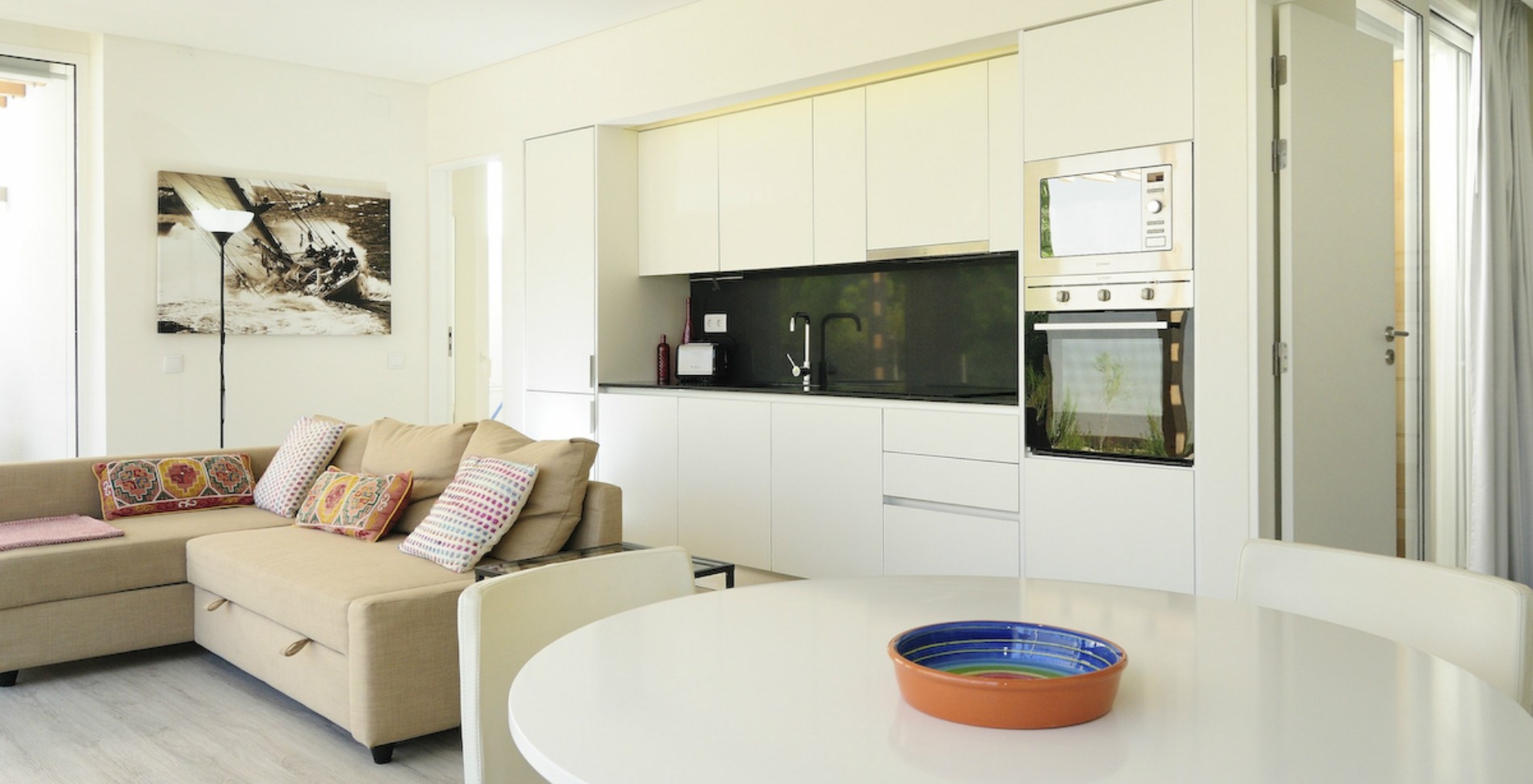 La Green Villa con Piscina Privada T3 del Pestana Tróia Eco Resort tiene una sala junta con la cocina, sofá y mesa para cenar