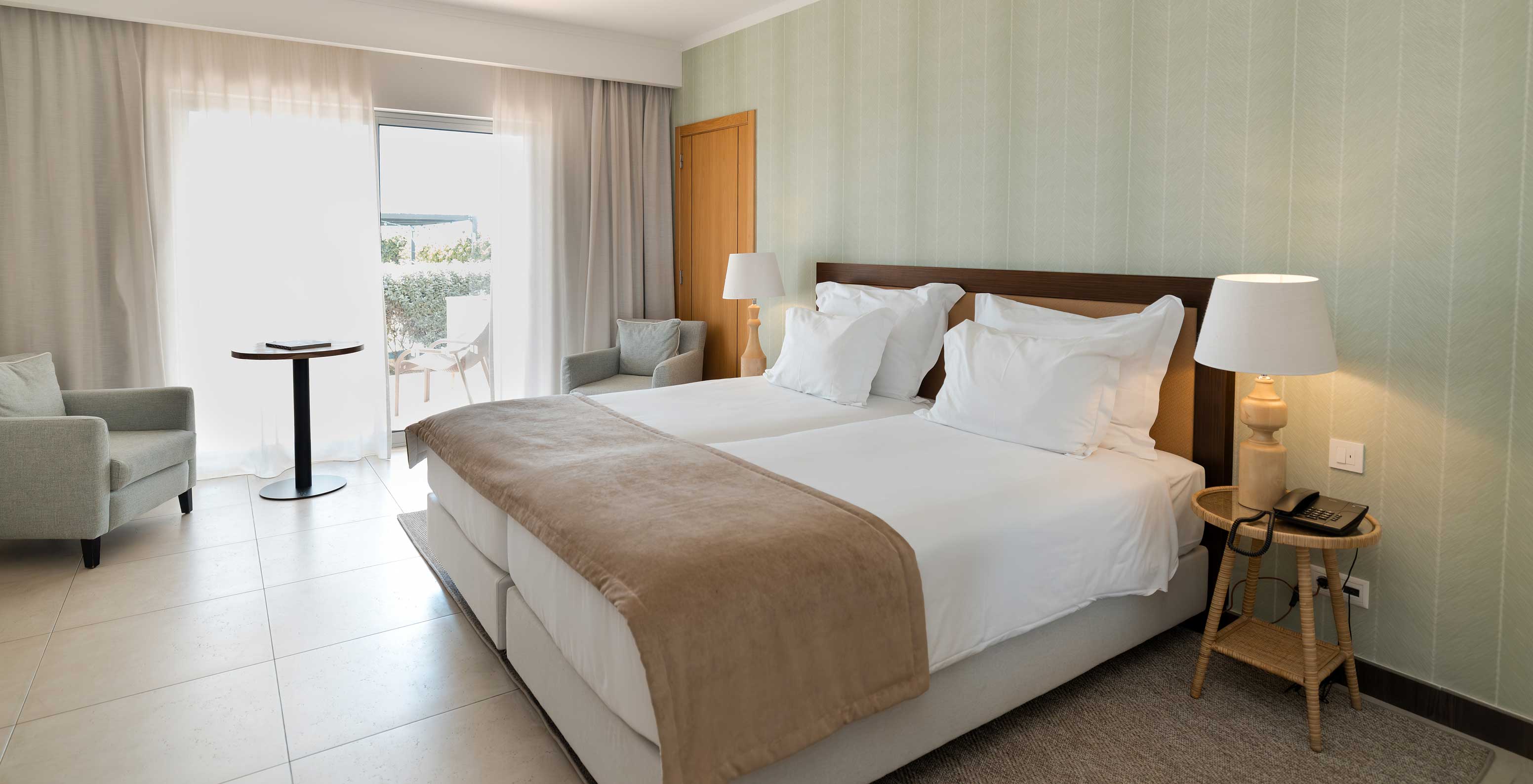 Estudio Vista Jardín en Pestana Alvor Beach Villas tiene dos camas, papel pintado verde y ventana con balcón