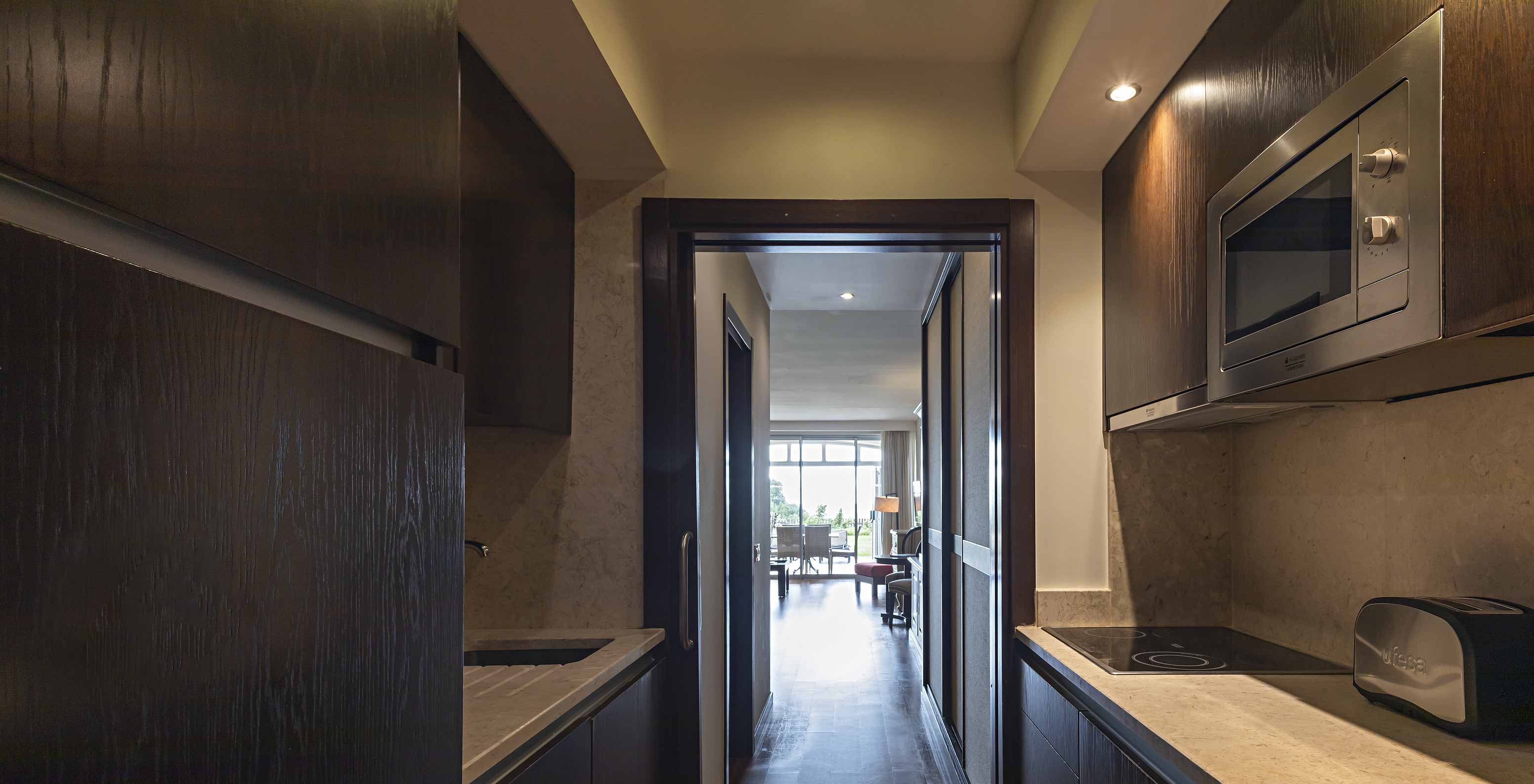 El Cliff Family en Pestana Alvor Praia tiene una cocina equipada en madera oscura y piedra, con una estufa y un microondas