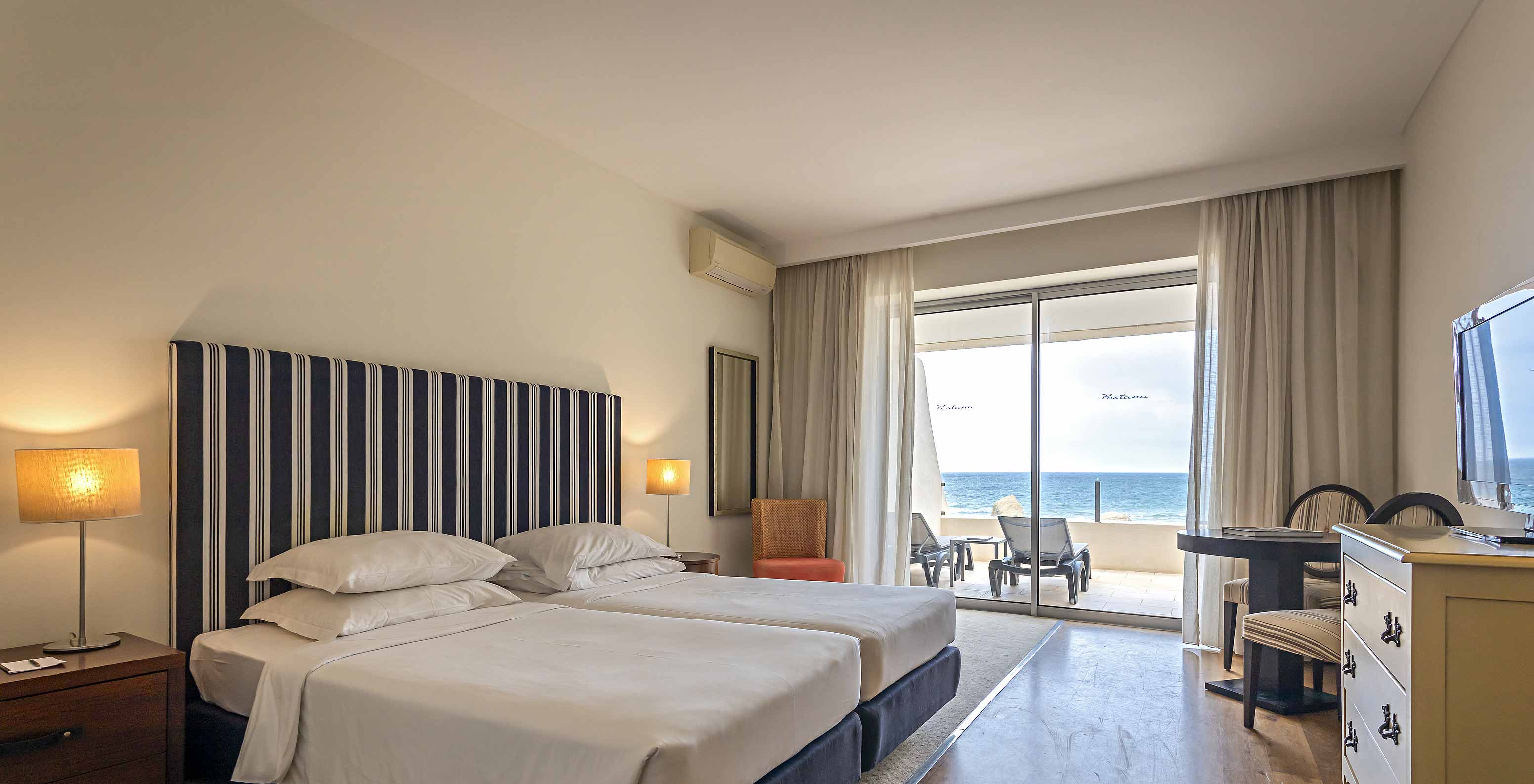 El Cliff Studio en Pestana Alvor Praia tiene un dormitorio doble con un balcón, tumbonas y vistas al mar
