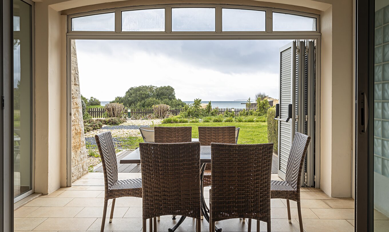El Cliff Family en Pestana Alvor Praia tiene un porche con una mesa y sillas, y un jardín con vistas a la playa