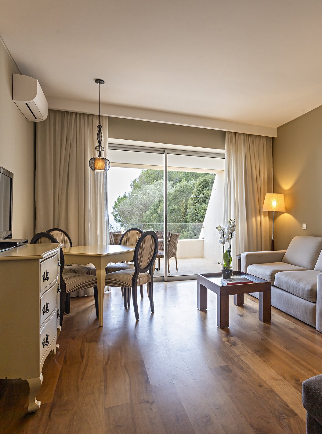 La Cliff Suite T1 en Pestana Alvor Praia tiene una sala de estar con dos sofás, una televisión, una mesa de comedor y sillas