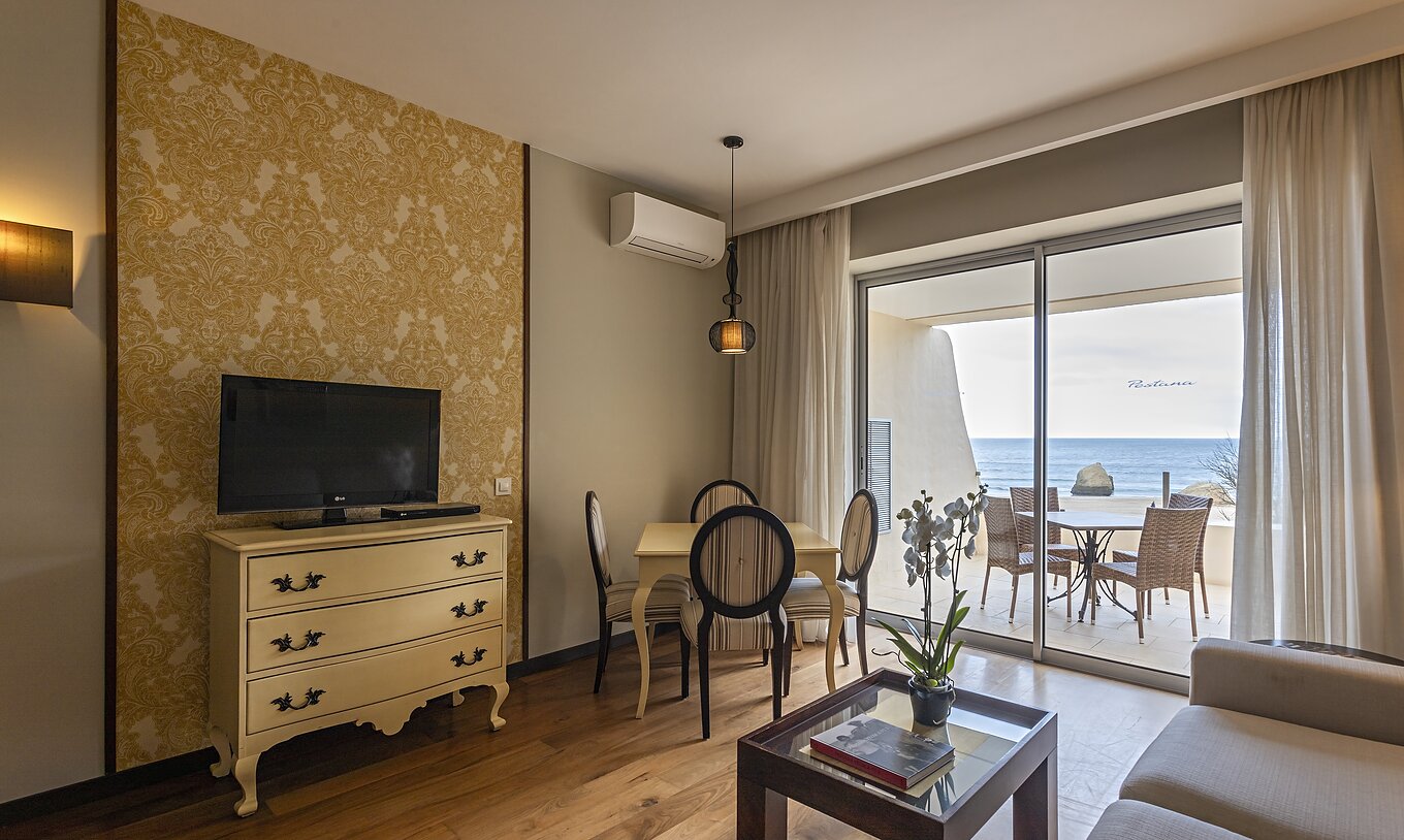 La Cliff Suite T1 en Pestana Alvor Praia tiene una sala de estar con televisión y un balcón con una mesa y vistas al mar