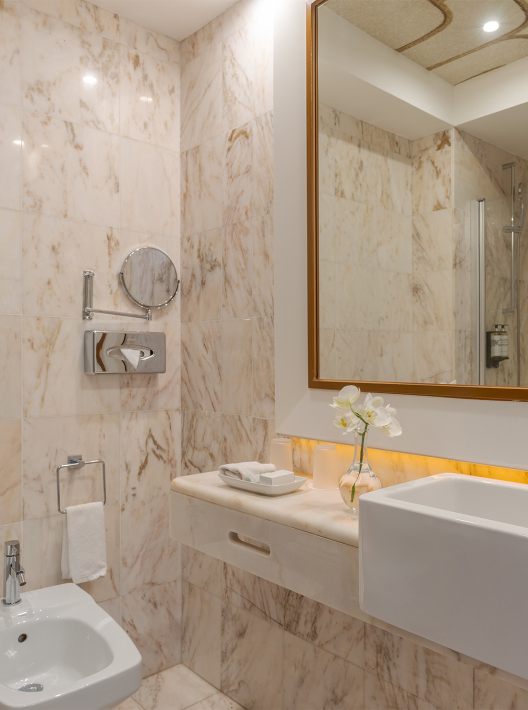 La Suite Vista Jardín del Pestana Alvor Praia tiene baño de mármol con bidé, lavabo, espejos y florero