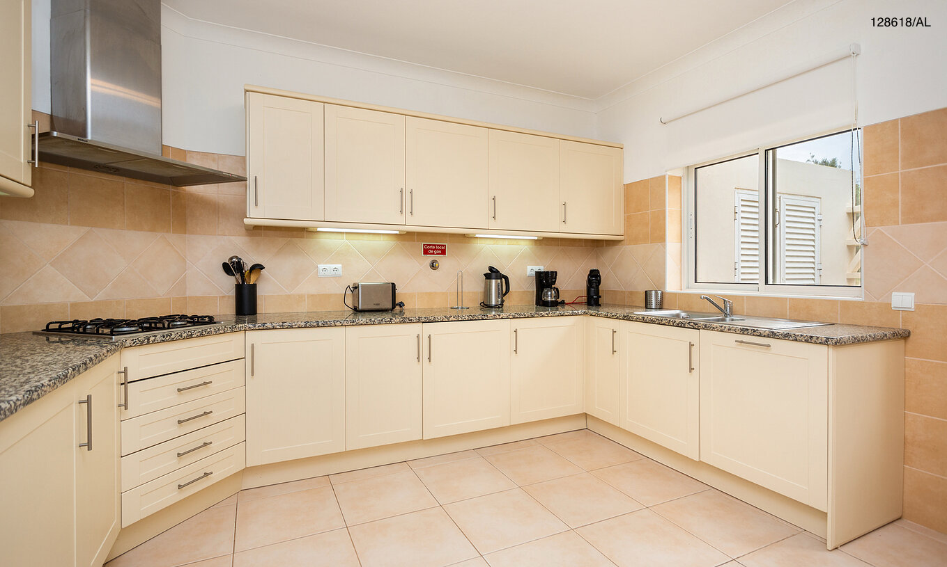 La villa Pestana Carvoeiro Golf V3 Superior tiene una cocina equipada con gabinetes blancos y electrodomésticos