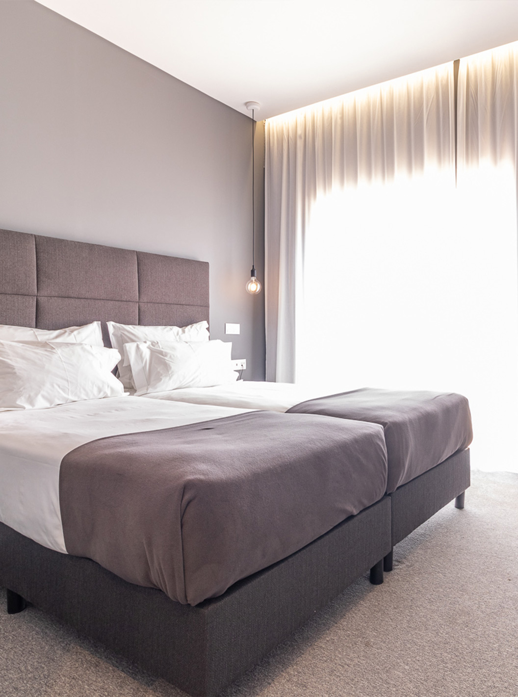 La Habitación Clásica Vista Piscina en Pestana Gramacho es moderna, con dos camas, cortinas grises y mesa con flores