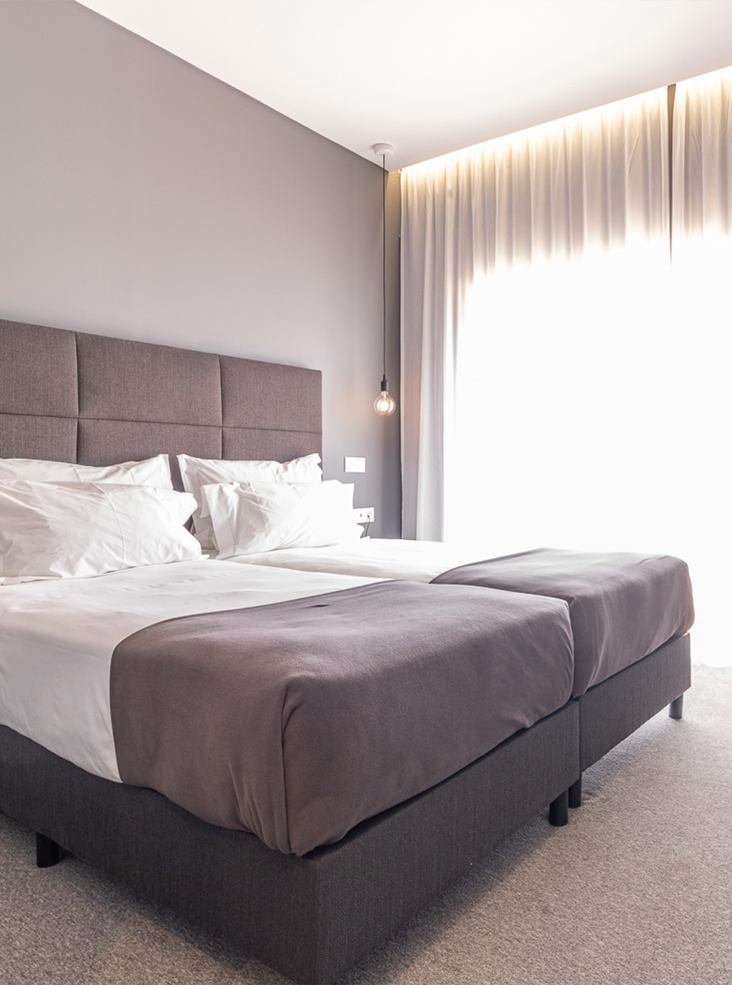 Habitación Clásica en Pestana Gramacho Residences con dos camas, cortinas y mesa con flores