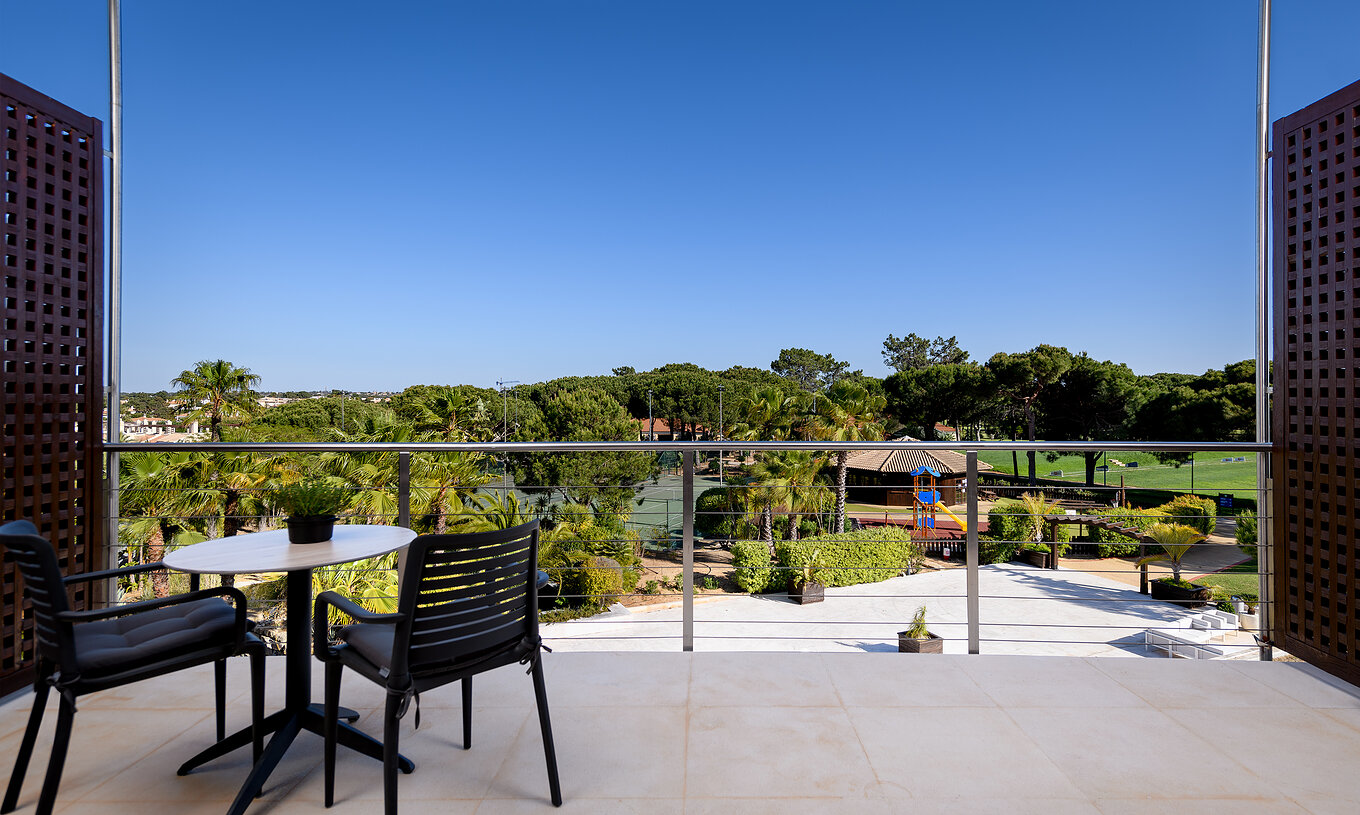 El Superior del Pestana Vila Sol - Vilamoura tiene un balcón con una mesa con sillas y vista a un campo de golf