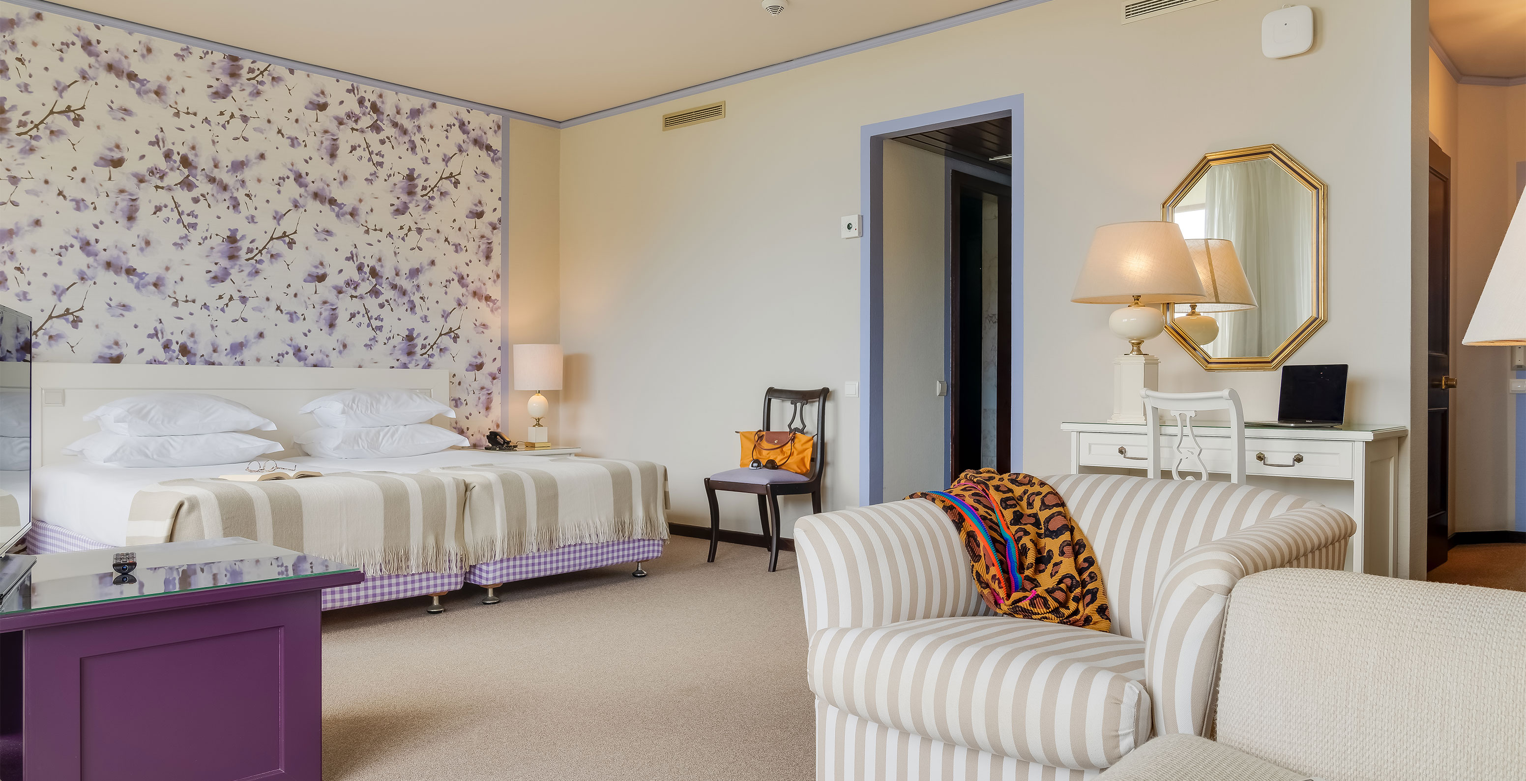 En la Junior Suite Vista Jardín del Pestana Bahia Praia, las camas están al lado del balcón con vista a jardines y al mar