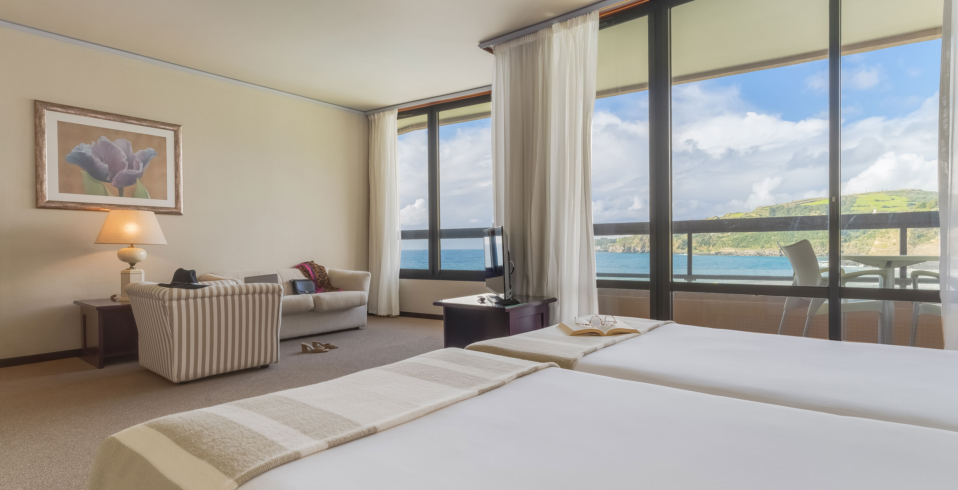 La Junior Suite Vista Mar del Pestana Bahia Praia tiene hermosa vista a la naturaleza verde y al mar, con acceso al balcón