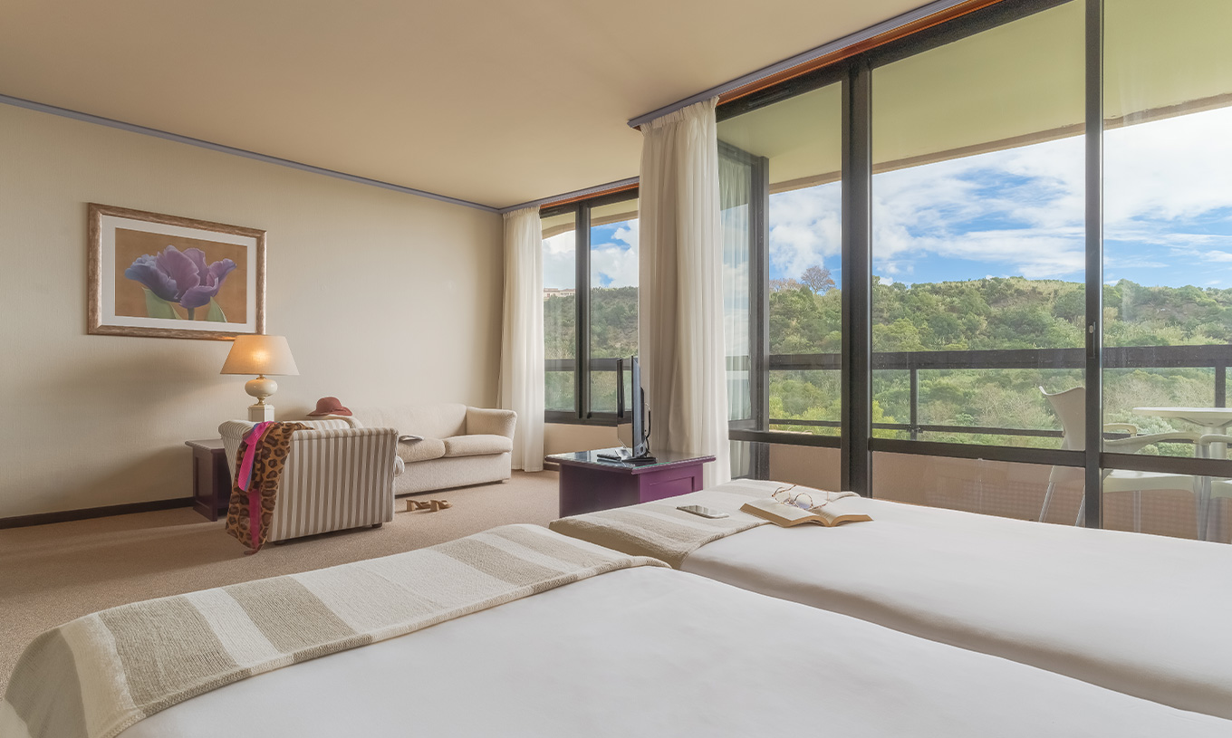 La Junior Suite Vista Jardín del Pestana Bahia Praia tiene hermosa vista a la naturaleza verde, con acceso al balcón