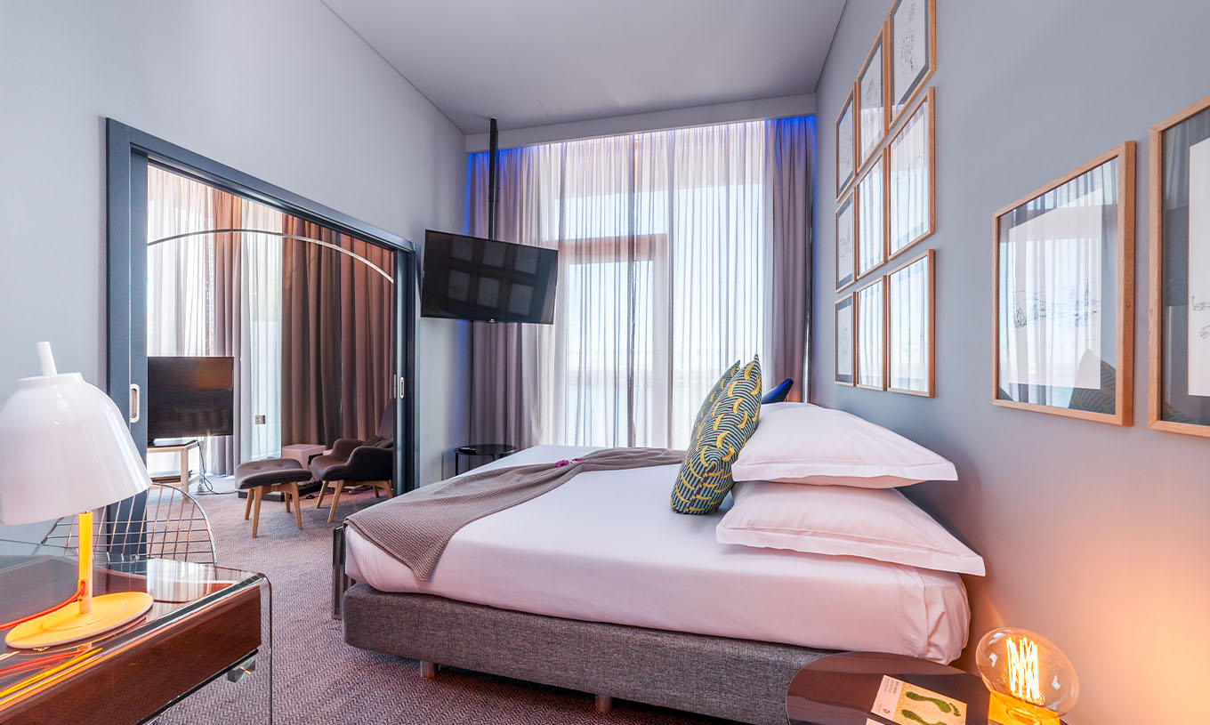 La Suite CR7 del Pestana CR7 Funchal tiene un cuarto con una cama doble, una televisión fija en la pared y una ventana