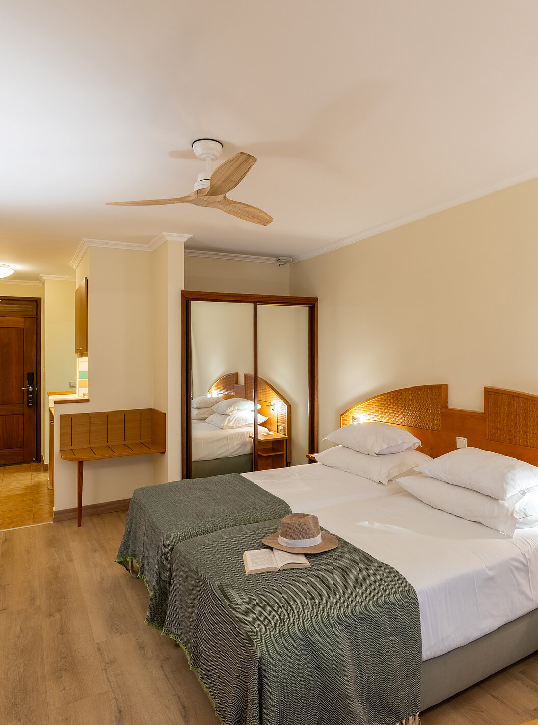 El Classic Pool View del Pestana Ocean Bay All Inclusive tiene dos camas individuales unidas con una colcha verde