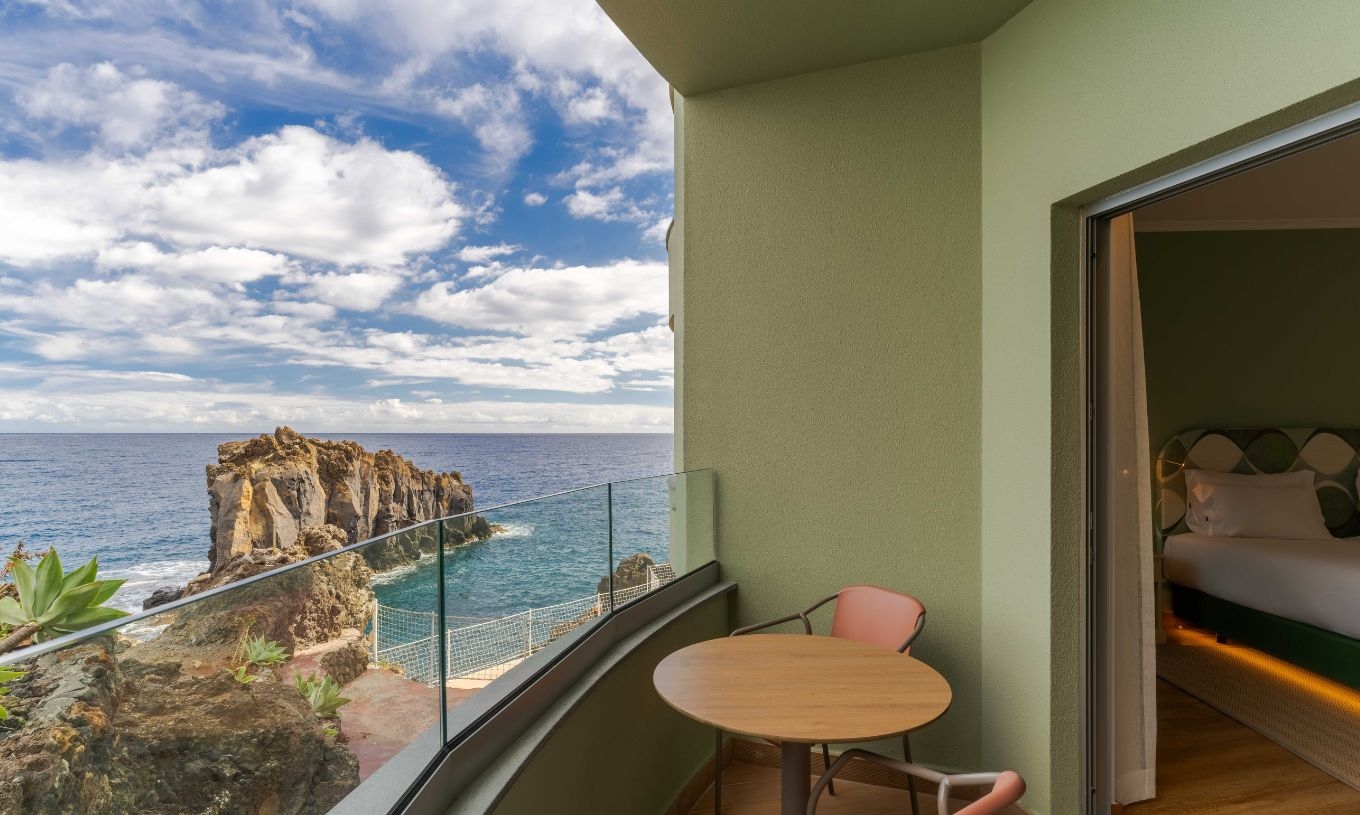 El Superior Vista Mar Lateral  en el Pestana Vila Lido Madeira tiene un balcón con mesa y sillas