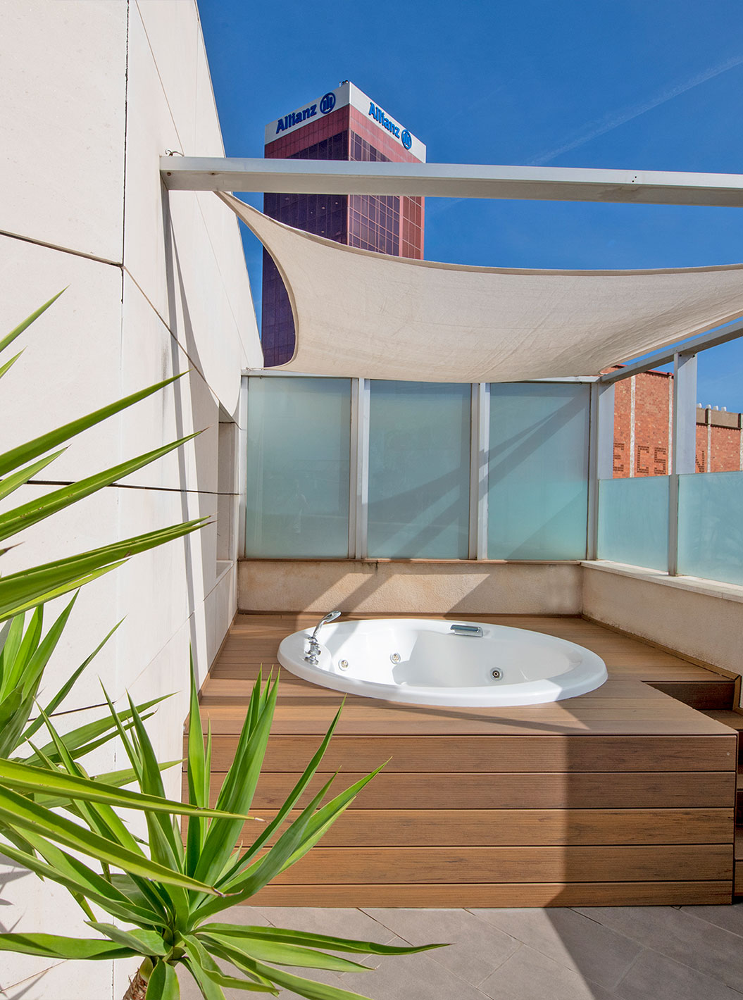 La Junior Suite con jacuzzi en la terraza del Pestana Arena Barcelona tiene terraza con jacuzzi, sillas y plantas