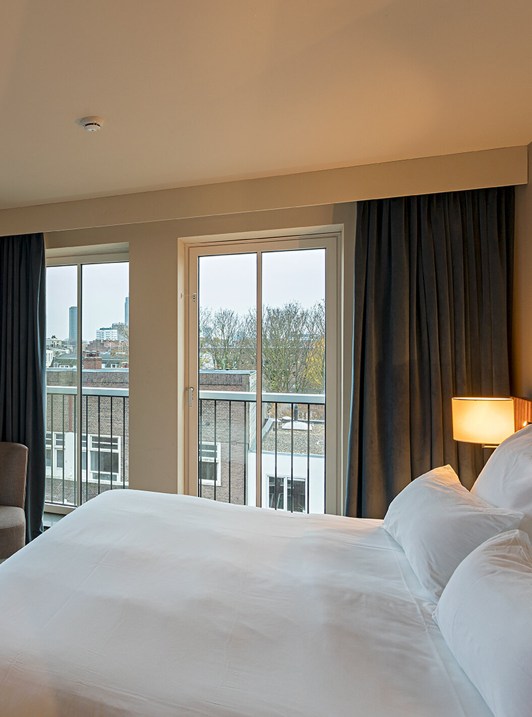 El cuarto Estudio Clásico del Pestana Amsterdam Riverside tiene una cama doble, una lámpara y ventanas con vista a la calle