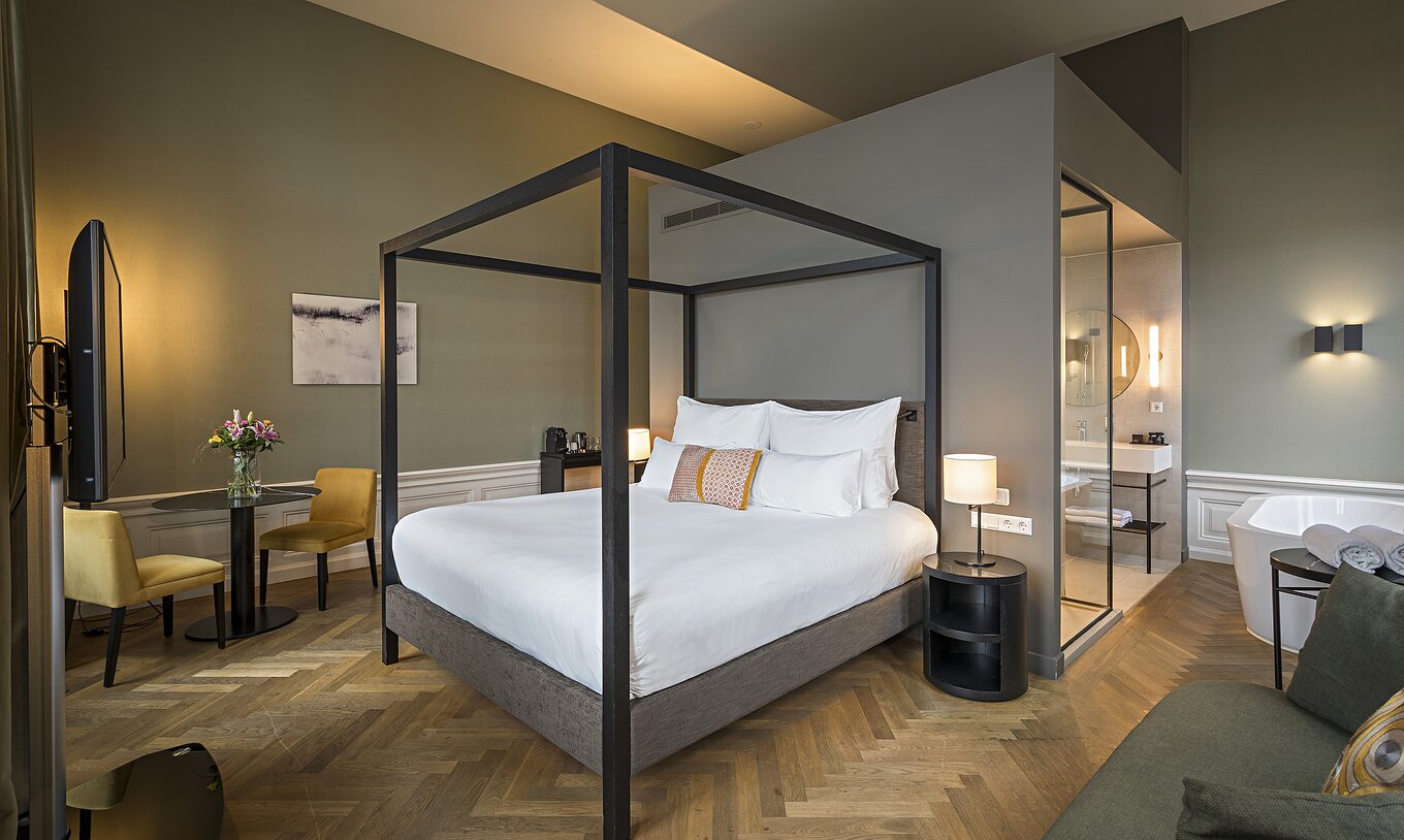 La Junior Suite - River View del Pestana Amsterdam Riverside tiene una cama con dosel y mesa con dos sillas