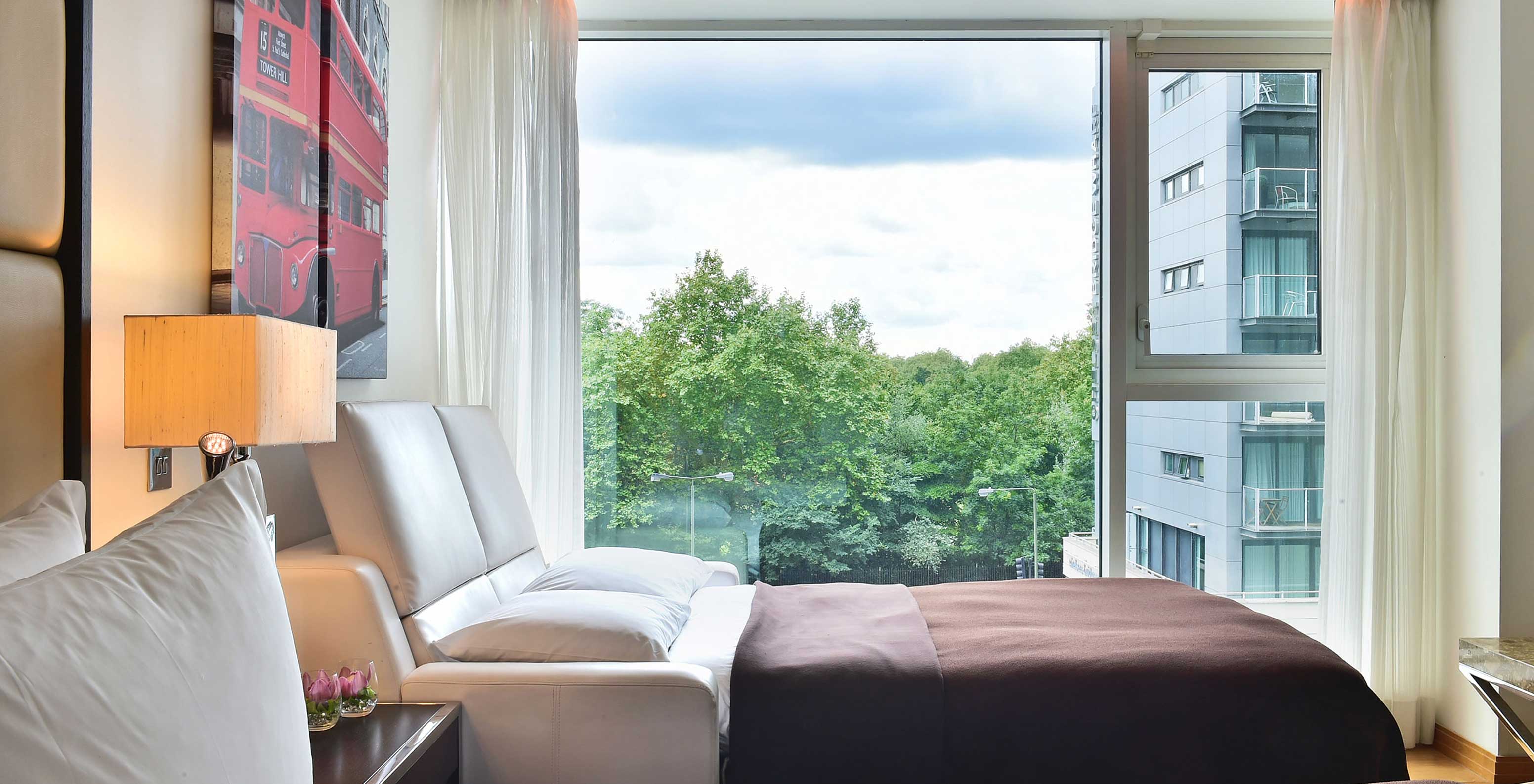 El Deluxe Family del Pestana Chelsea Bridge tiene sofá cama abierto, cuadros de Londres, ventana grande y cortinas