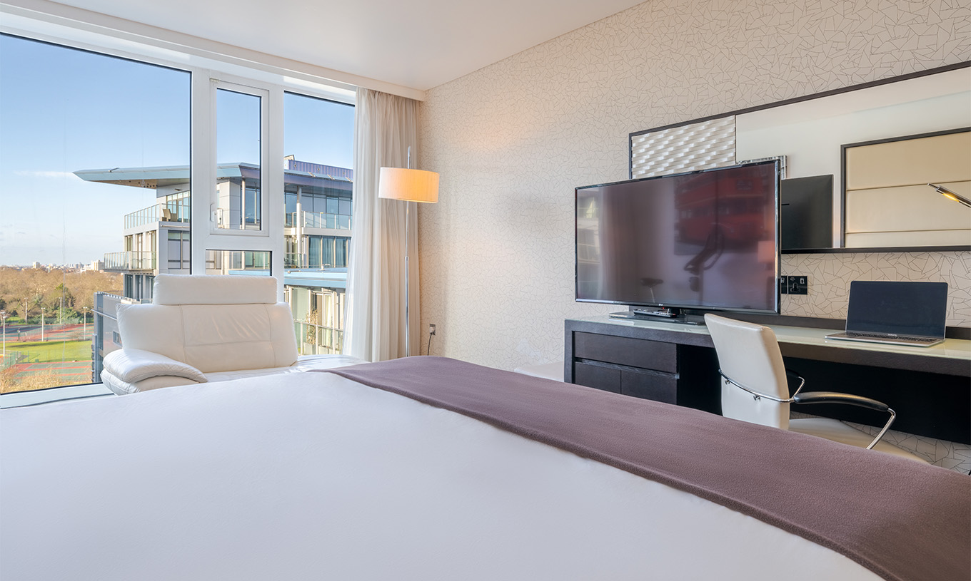 El Deluxe Premium King del Pestana Chelsea Bridge tiene cama doble, un escritorio con televisión, sofá y ventanas a la ciudad