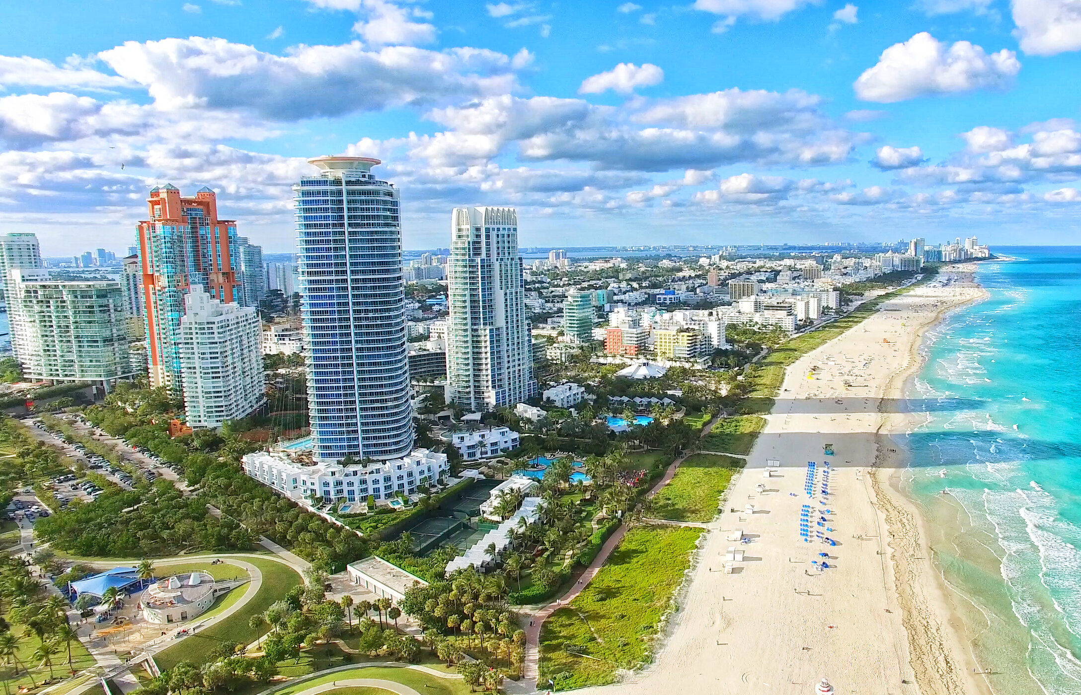 Vista sobre la playa de arena blanca en South Beach, con aguas cristalinas y edificios altos paralelos a la playa