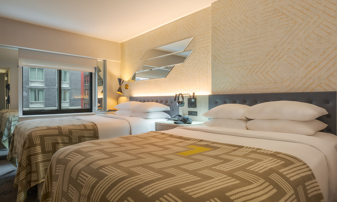 El Comfort Double del Pestana CR7 Times Square tiene dos camas con colcha con el número siete y una ventana