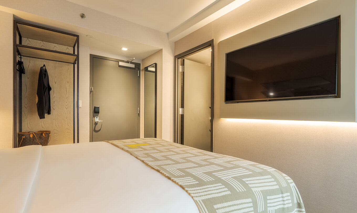 El Comfort ADA del Pestana CR7 Times Square tiene una cama doble con una colcha con el número siete y una televisión