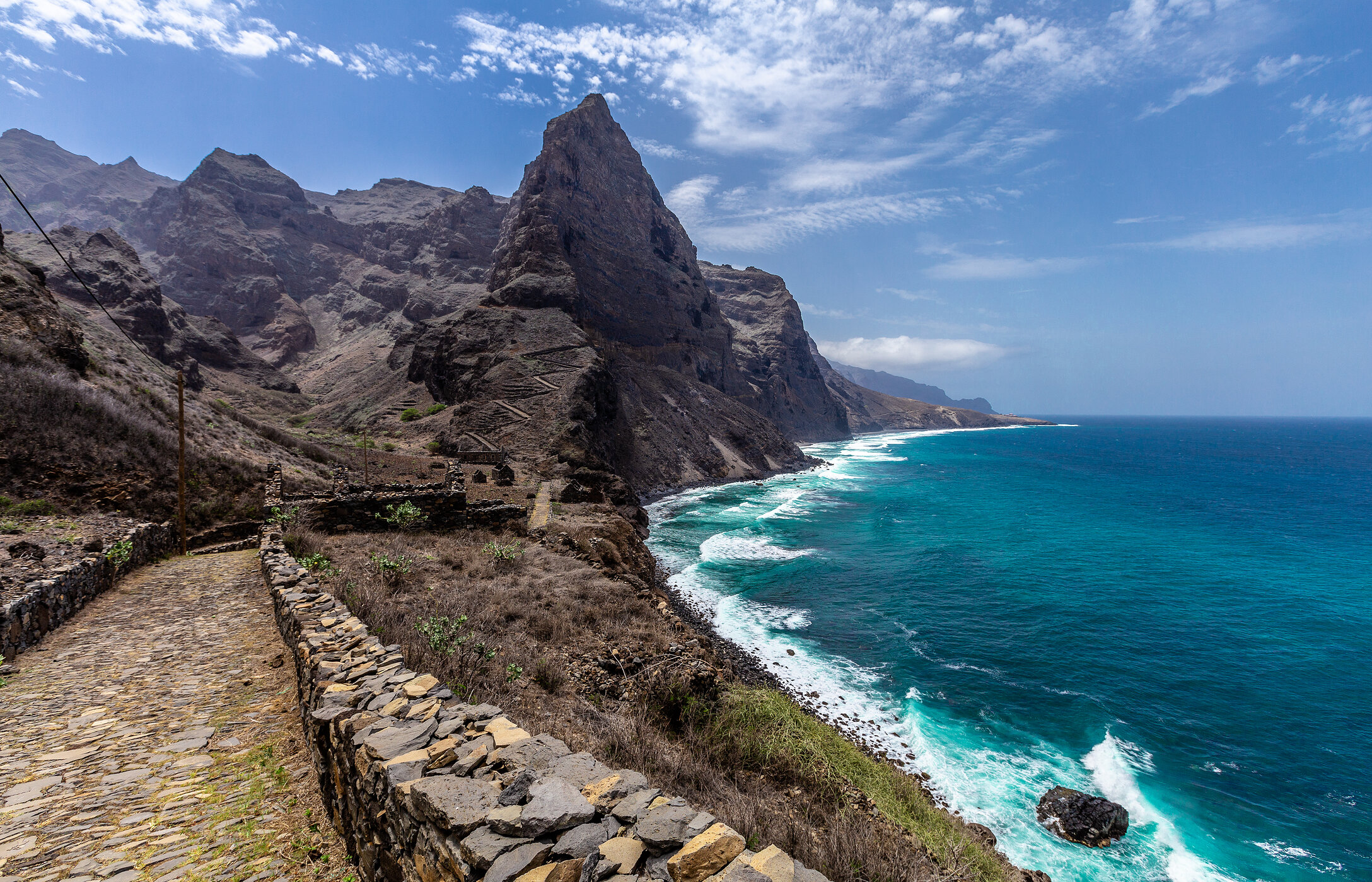 Sendero de piedra serpentea a lo largo de la costa con un acantilado empinado en la isla de Santo Antão, Cabo Verde.
