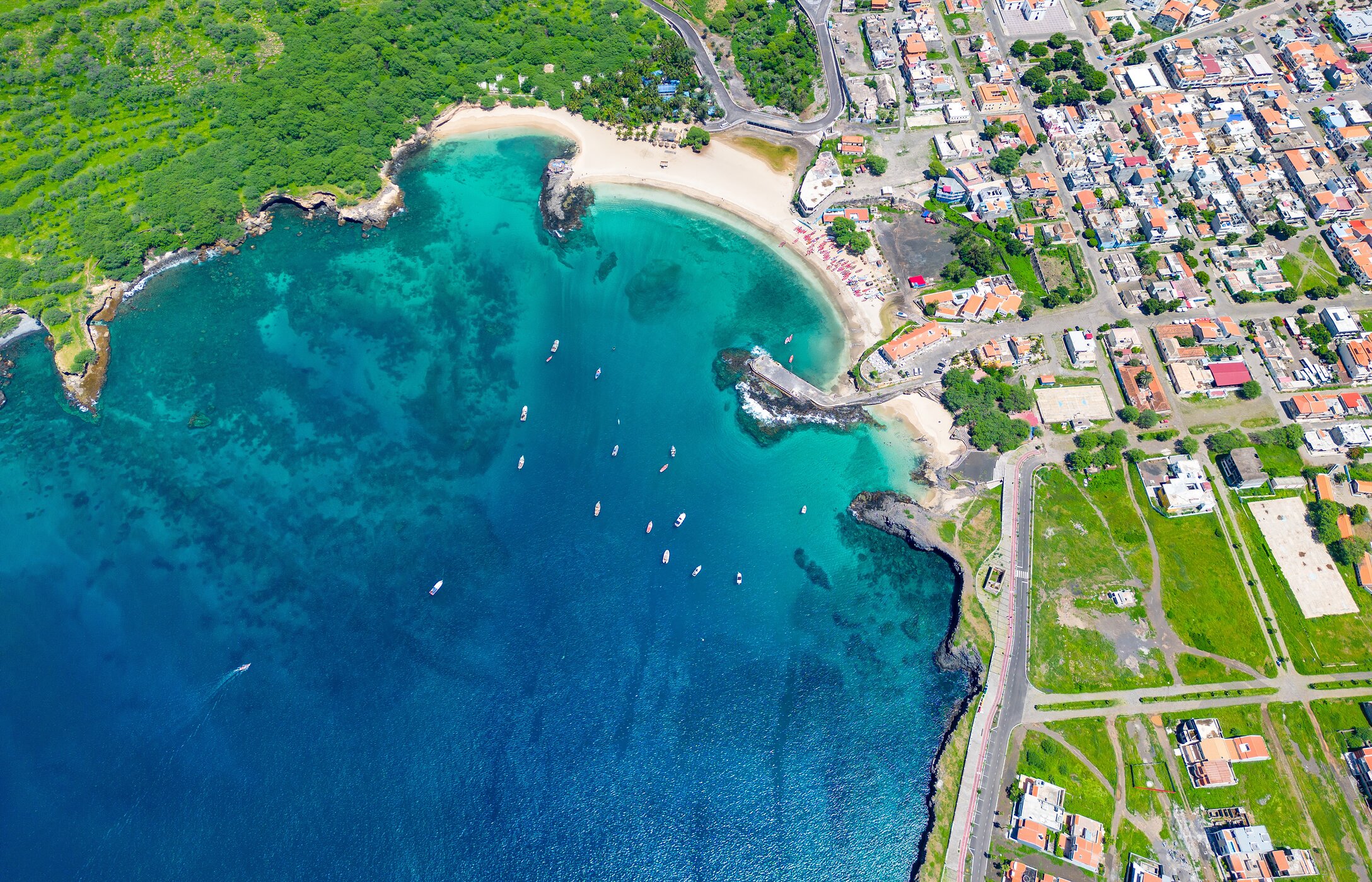 Vista aérea de la Playa de Tarrafal en Cabo Verde, con sus aguas cristalinas, arena blanca y vegetación circundante.