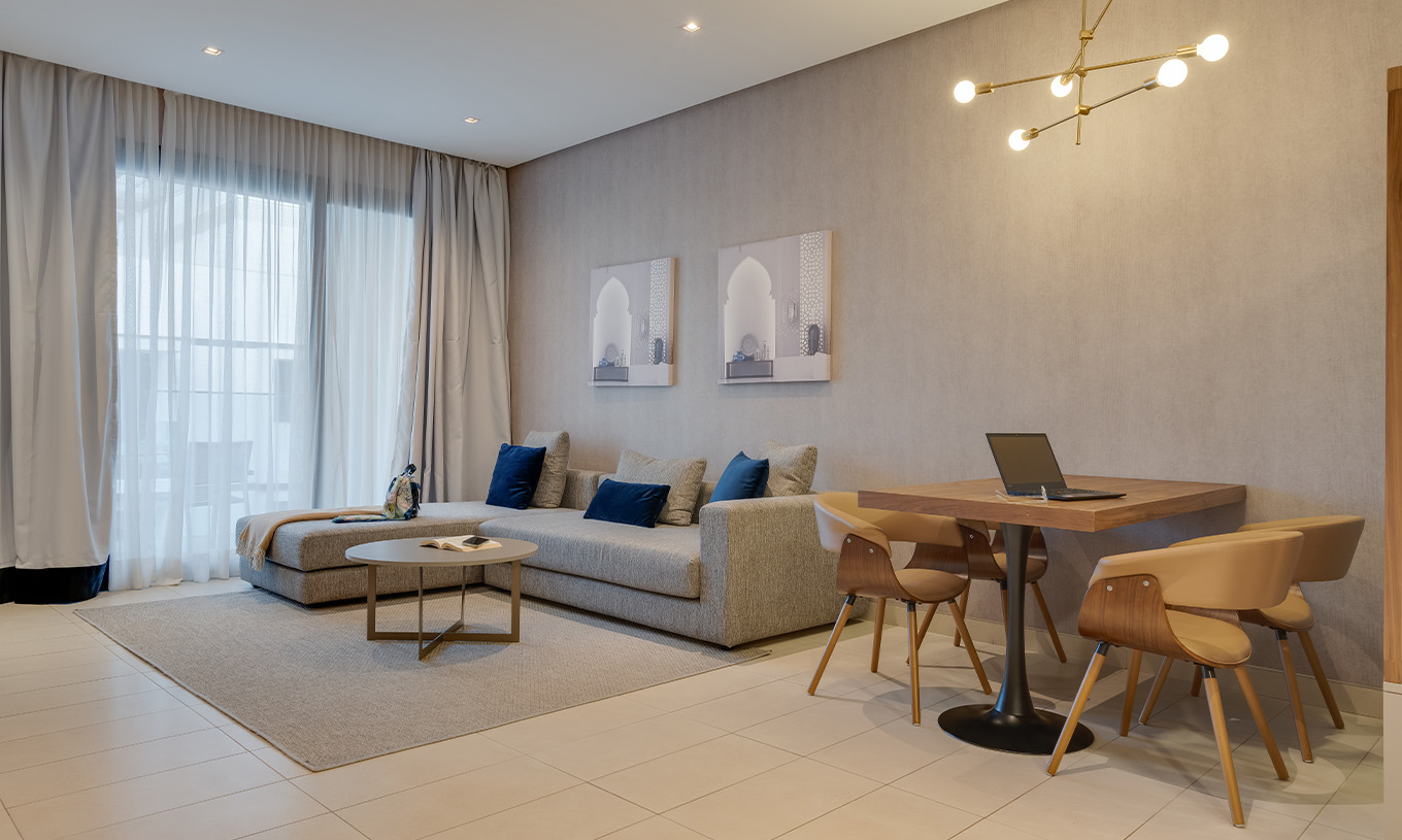 La Family Suite Premium Superior del Pestana Casablanca tiene un sofá gris grande con chaise longue cerca de la ventana
