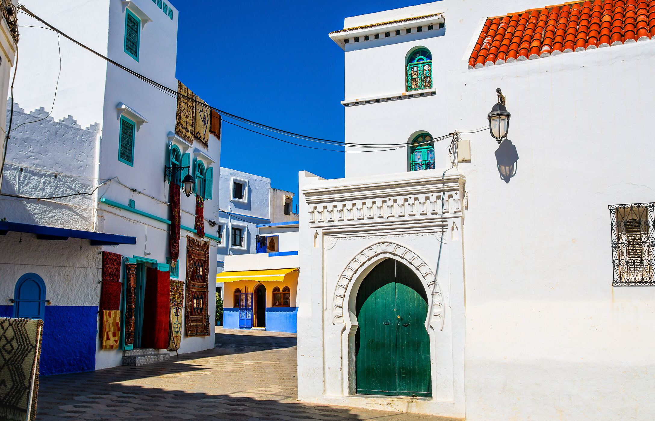 Por las estrechas calles de Tánger, es posible pasear por rincones coloridos con tapices colgantes