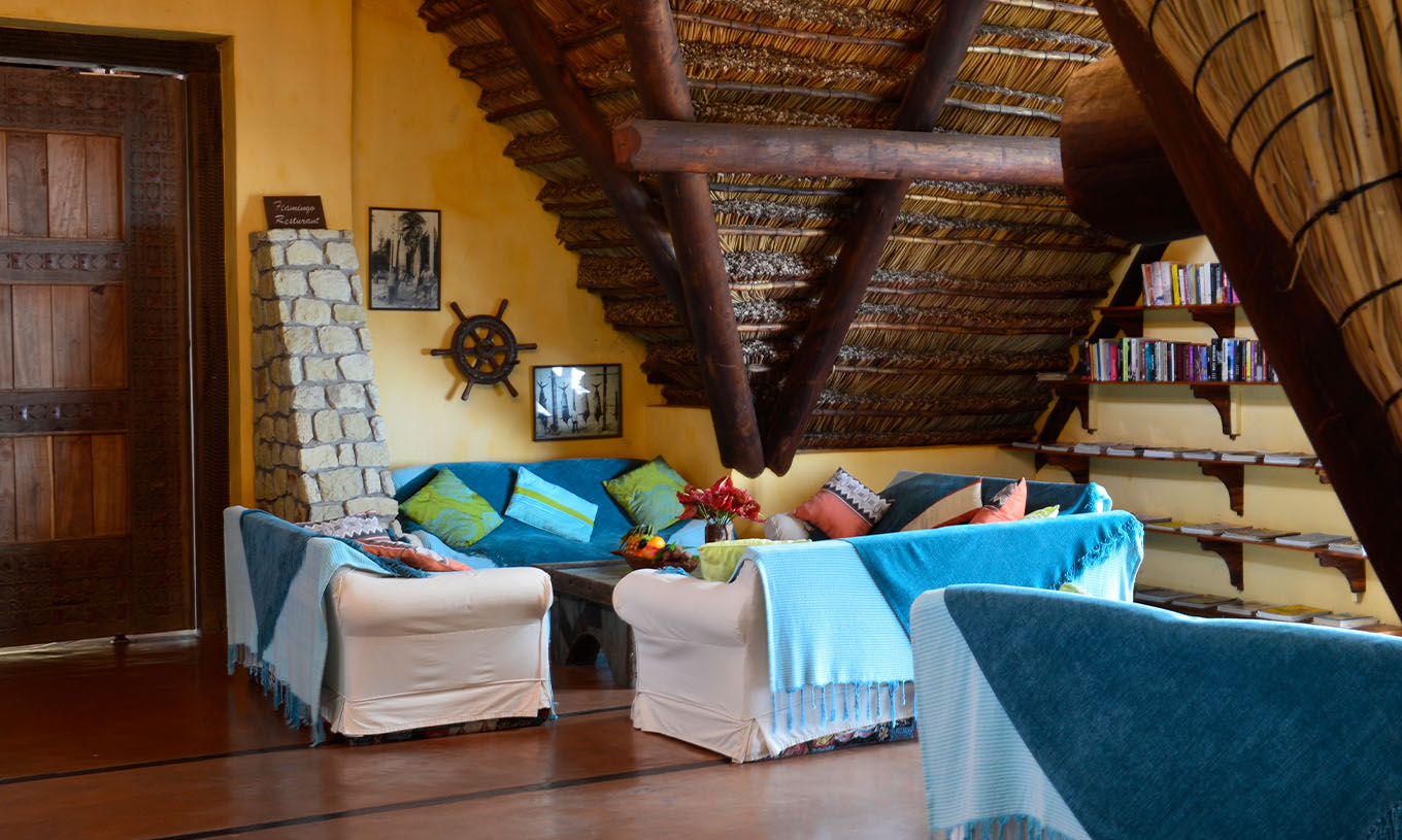 El Bungalow Suite T2 del Pestana Bazaruto Lodge tiene sala amplia con sofás cubiertos con mantas azules y cojines coloridos