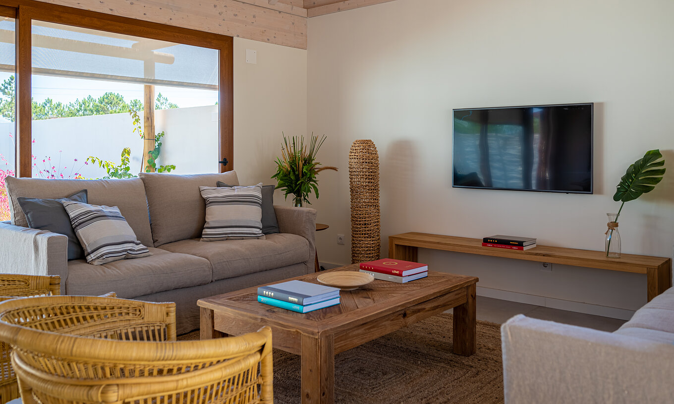 La Standard Villa (2 adultos) de Pestana Comporta Village Residences tiene una sala de estar con sofá y TV en la pared